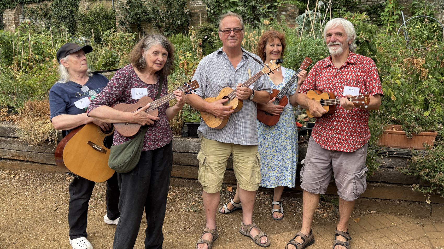 Five people playing ukuleles and guitars