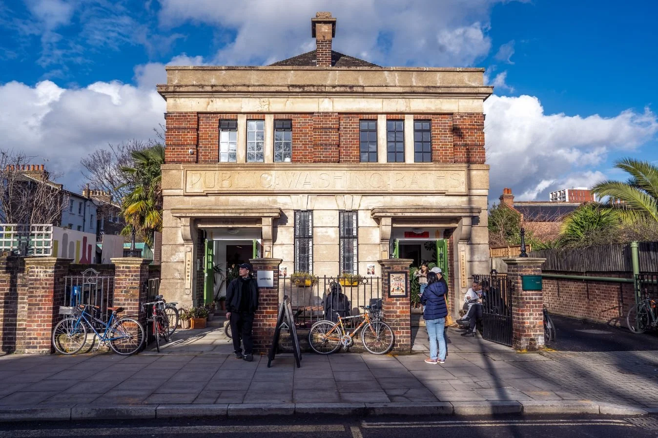 A colour photo of Hackney's East and South East Asian Community Centre, which is a building with two doors and two windows. A shaft of sunlight falls across the building.