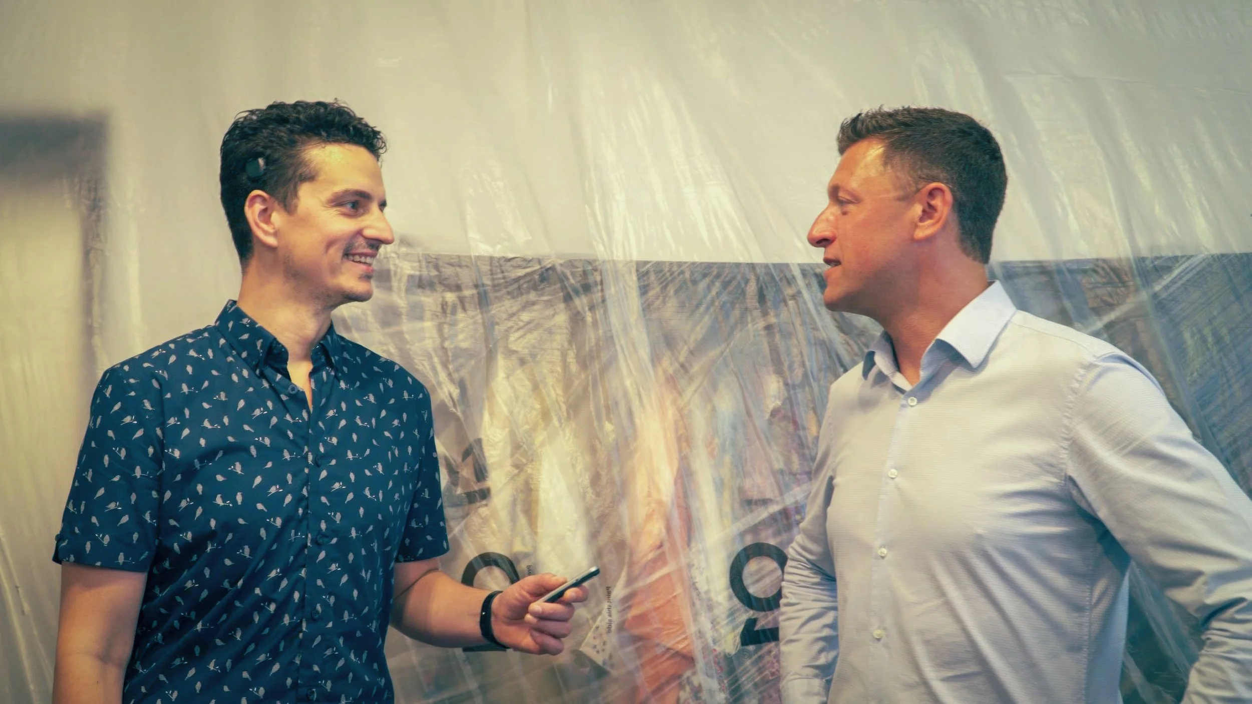 Two men talking in front of an internal building site