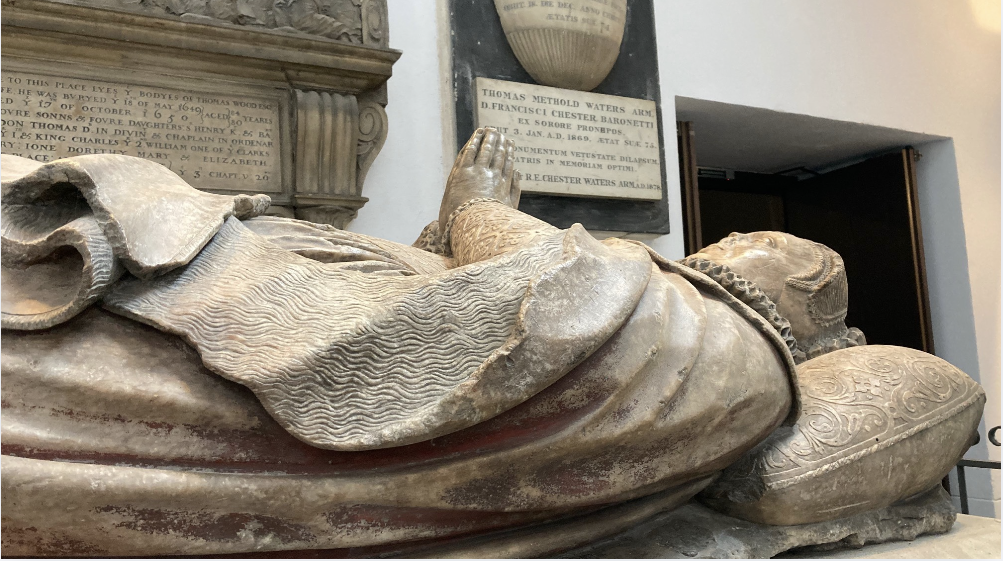 An old grave tomb featuring a woman lying down