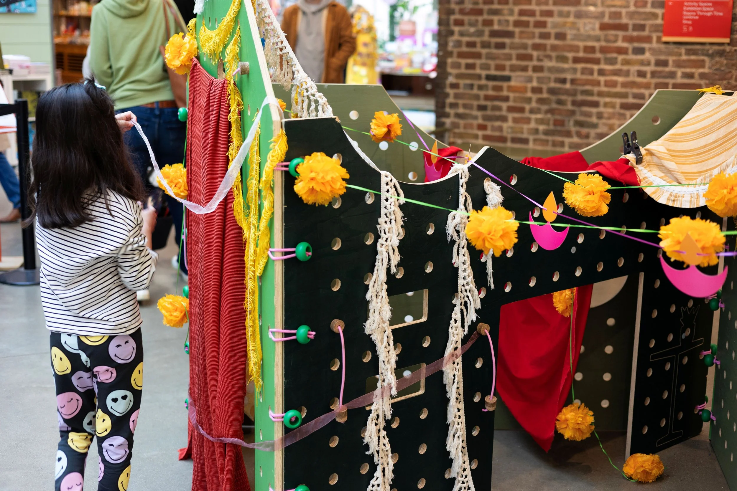 A child makes a colourful den at the Museum of the Home