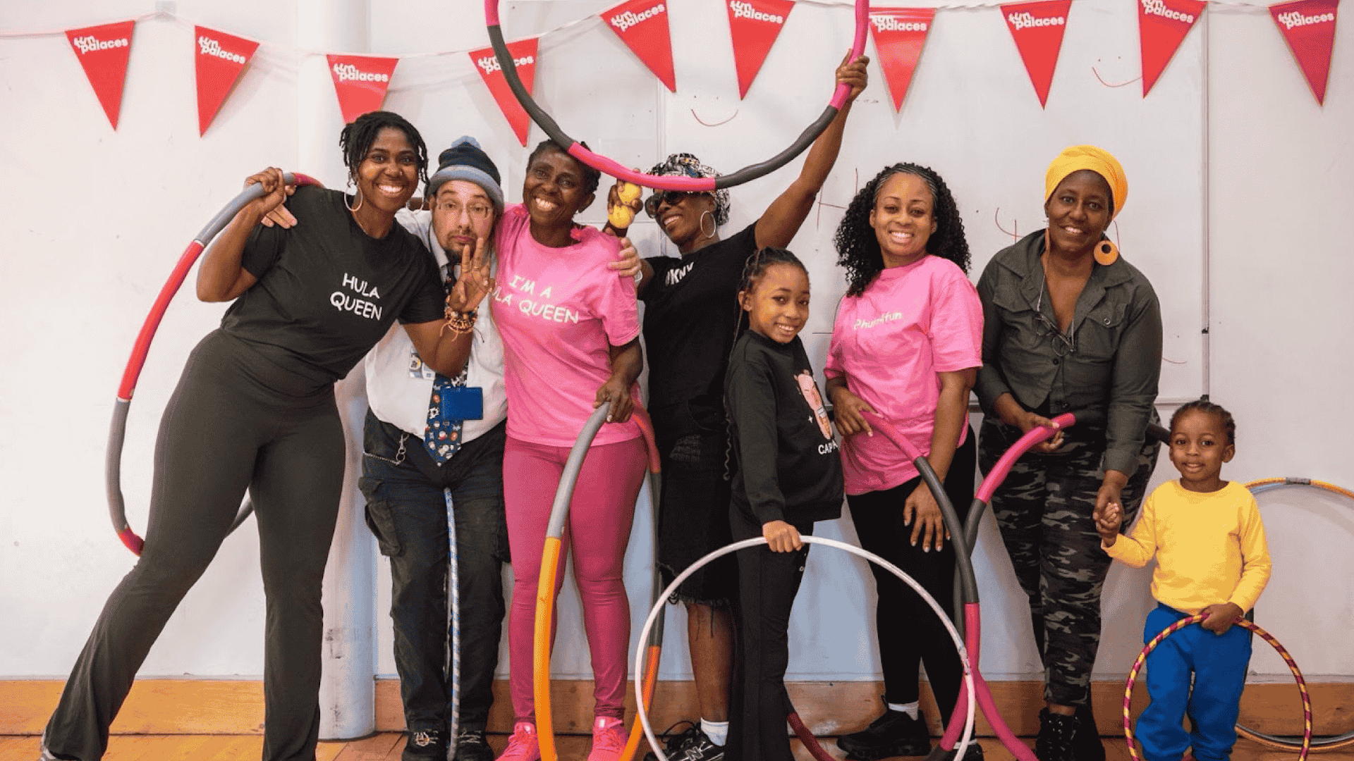 A group of people of all ages smiling holding hula hoops