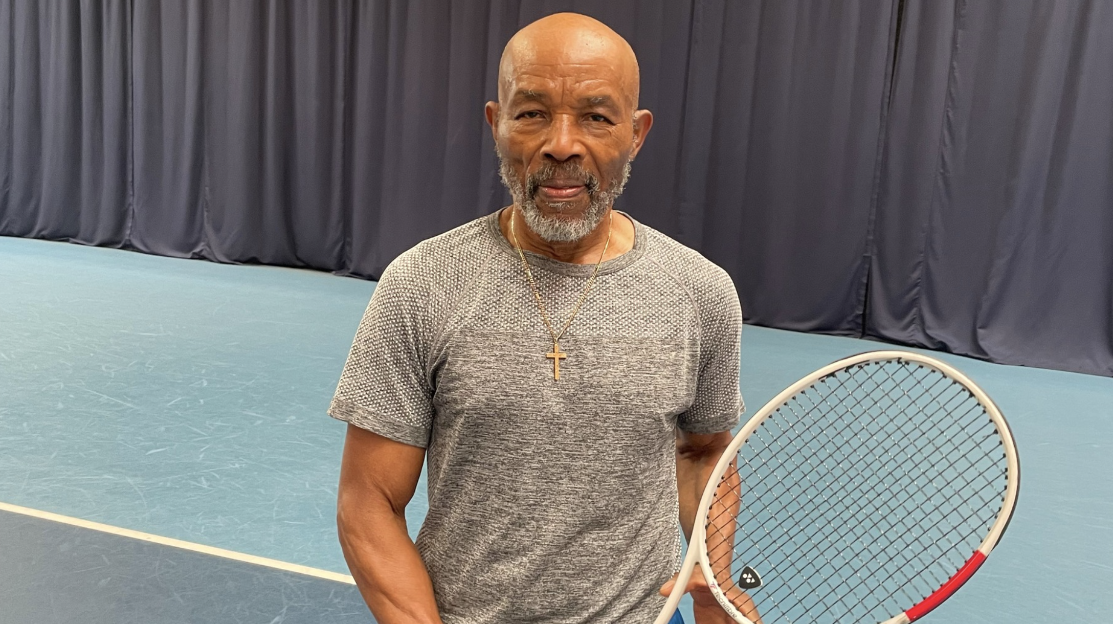 An older man with a tennis raquet