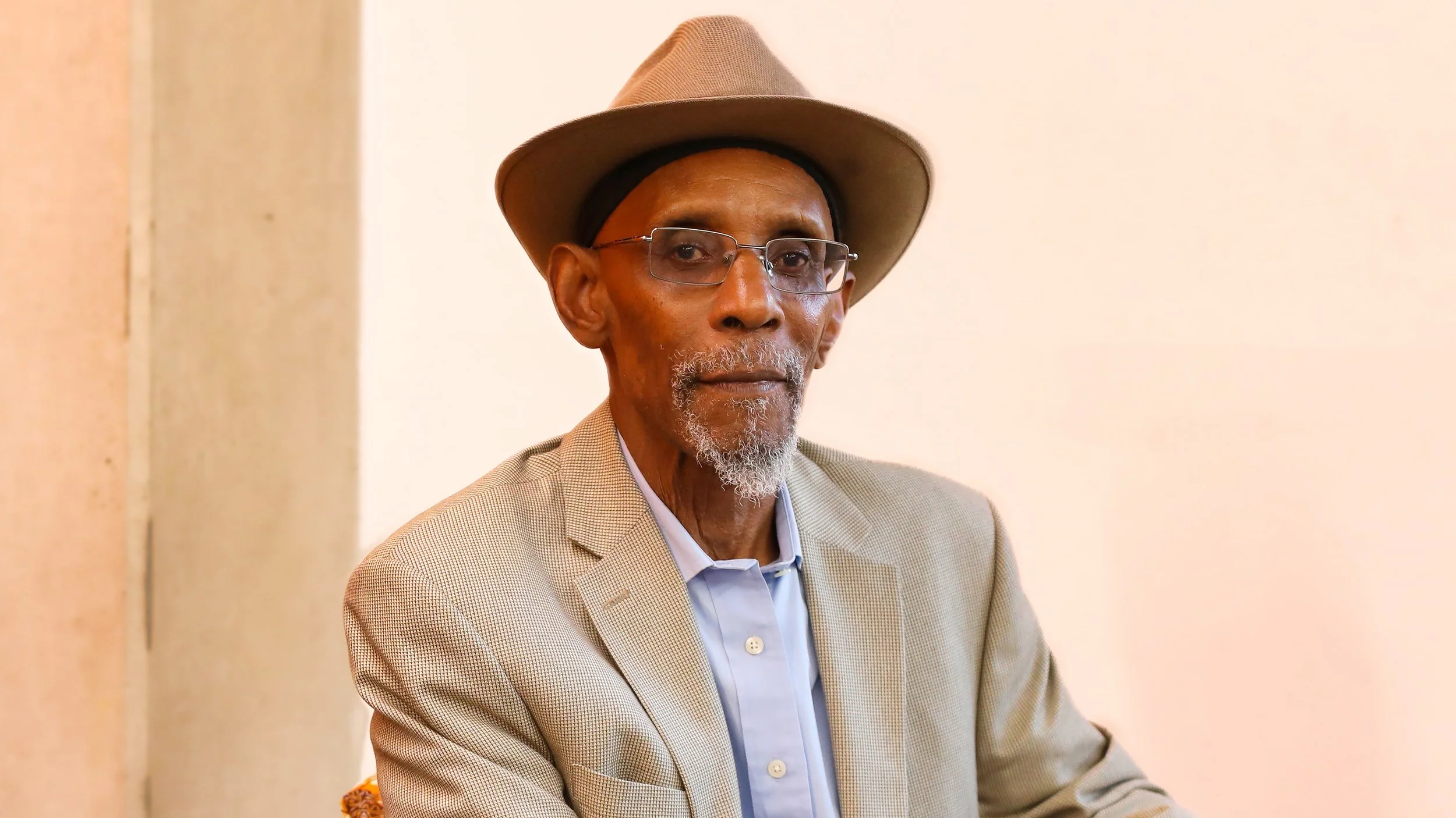 Poet Linton Kwesi Johnson wearing a hat and glasses