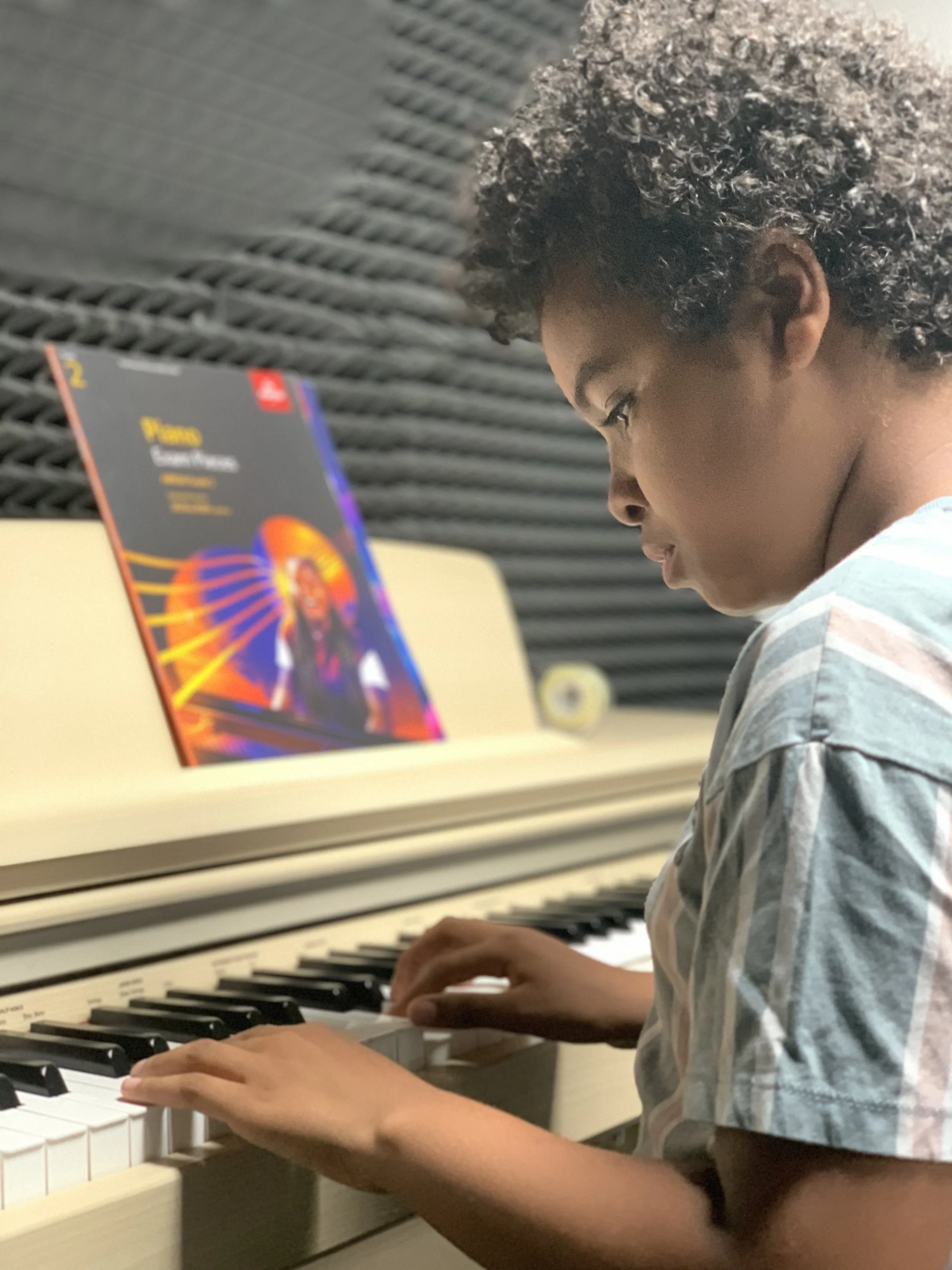 A young boy playing a piano
