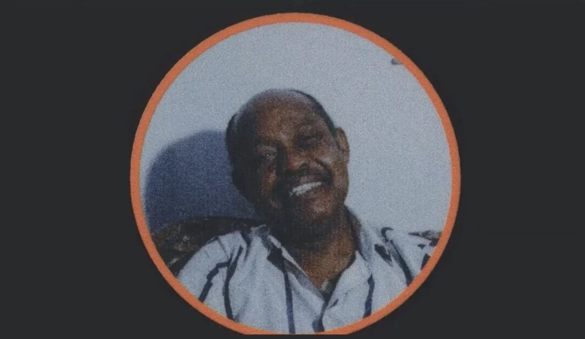 A grainy photograph of a man smiling