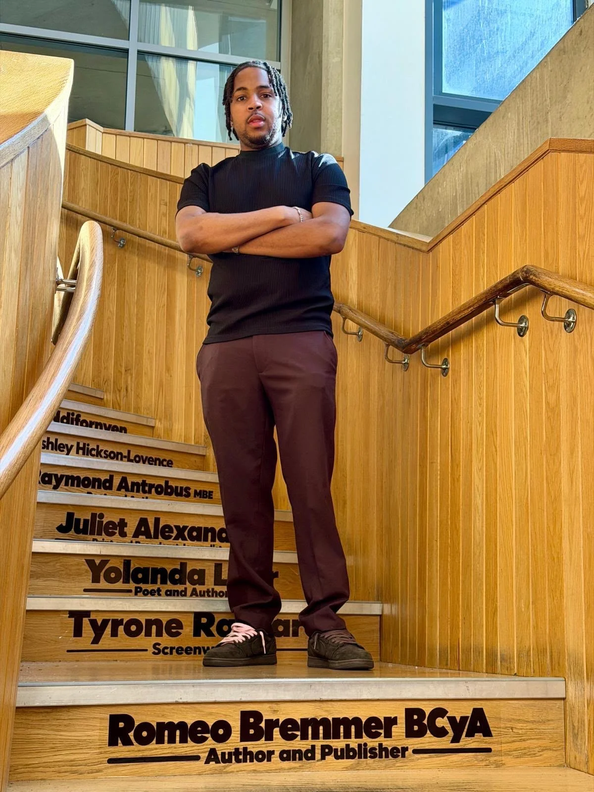 Author and Publisher Romeo Bremmer on the Legacy Steps at Dalston’s CLR James Library, standing above his name.