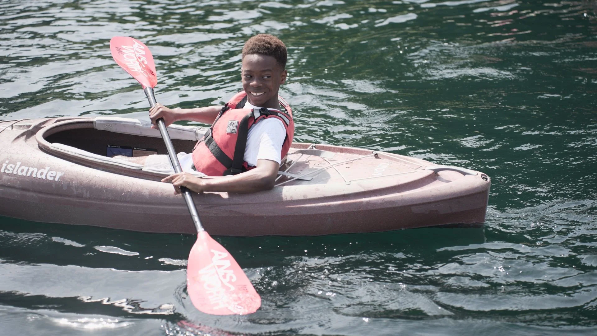 A young black boy enjoys canoeing 