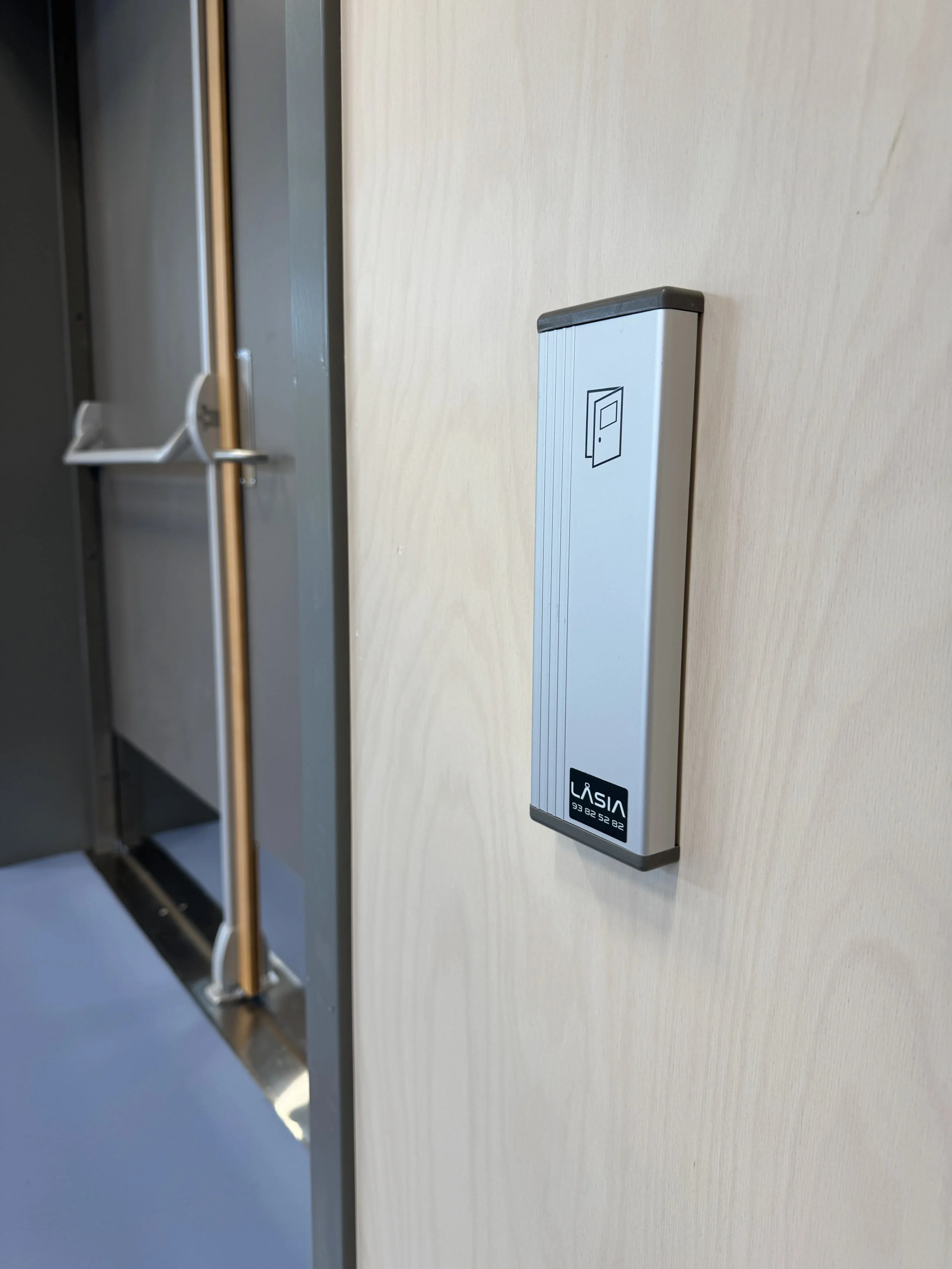 Elektronisk lås montert på panelet ved siden av en dør i et kontor eller bygg.