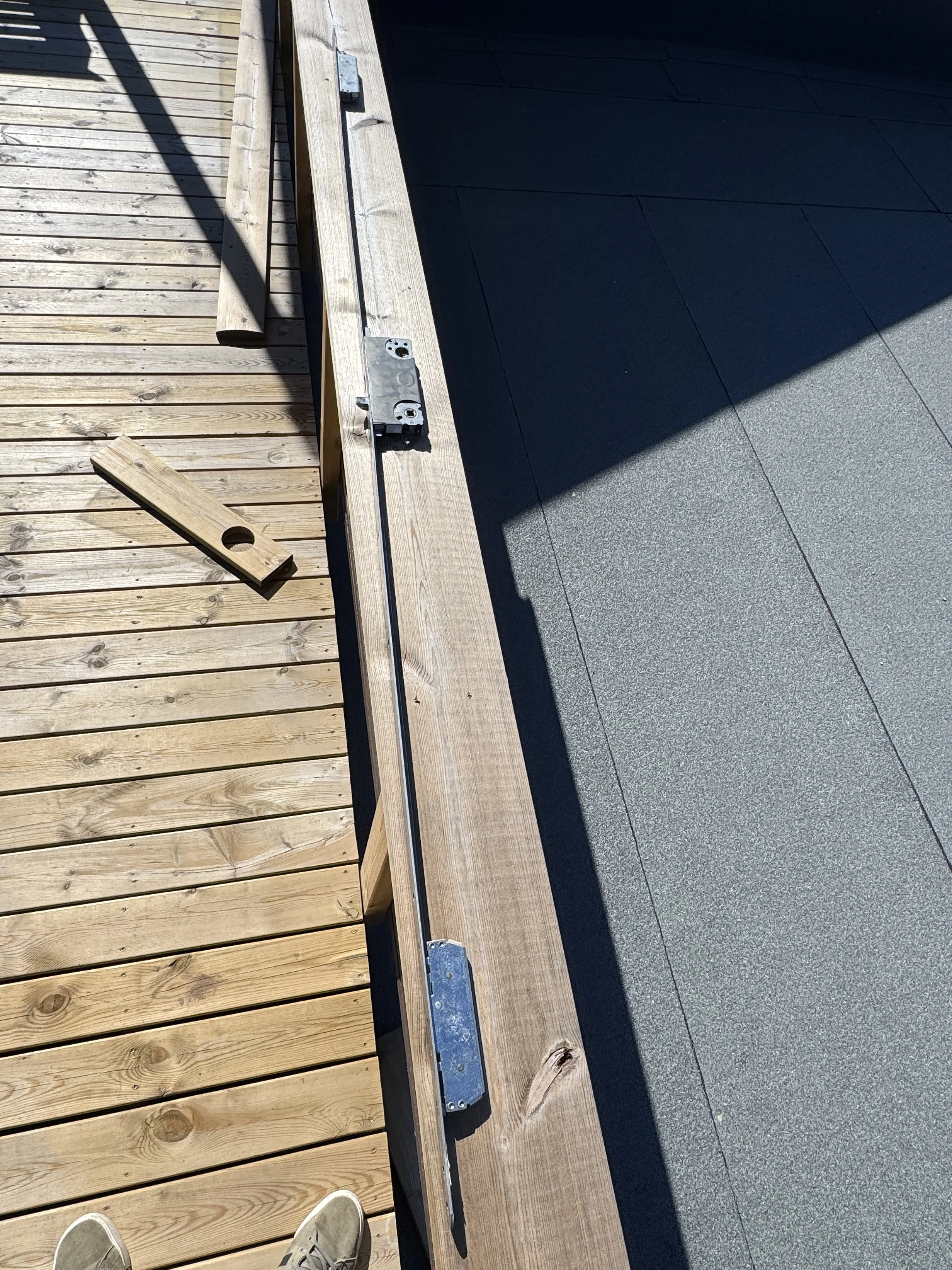 Bild av en byggesknagg på en treplattform med benker og verktøy liggende på plattformen.