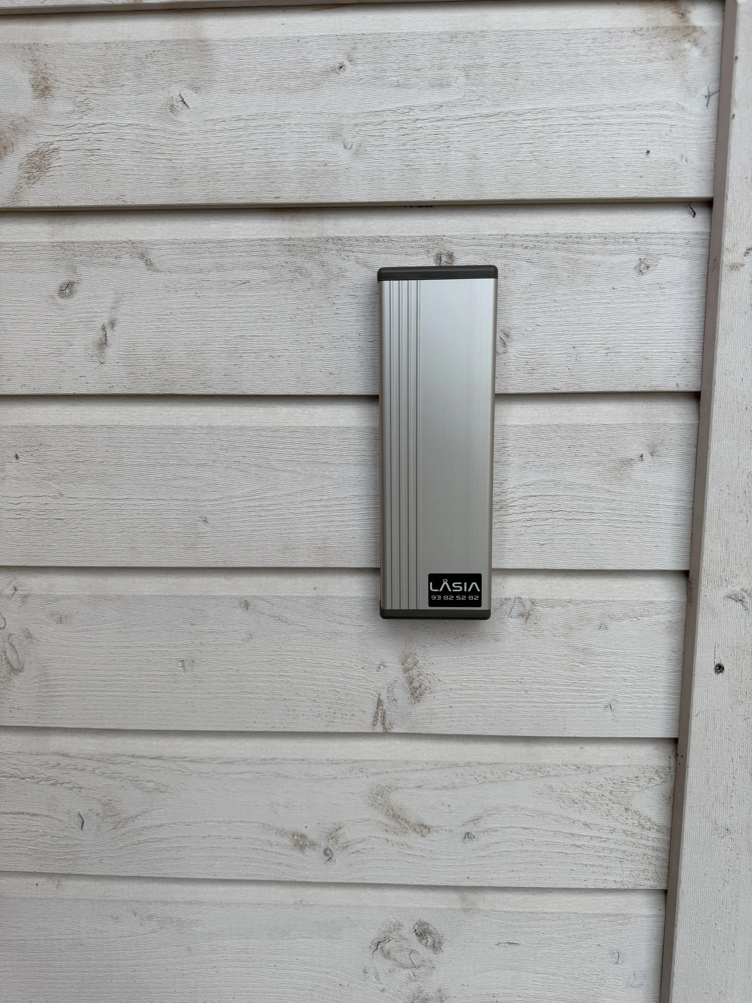 Utsikt av en metallpost montert på en hvit trevegg.