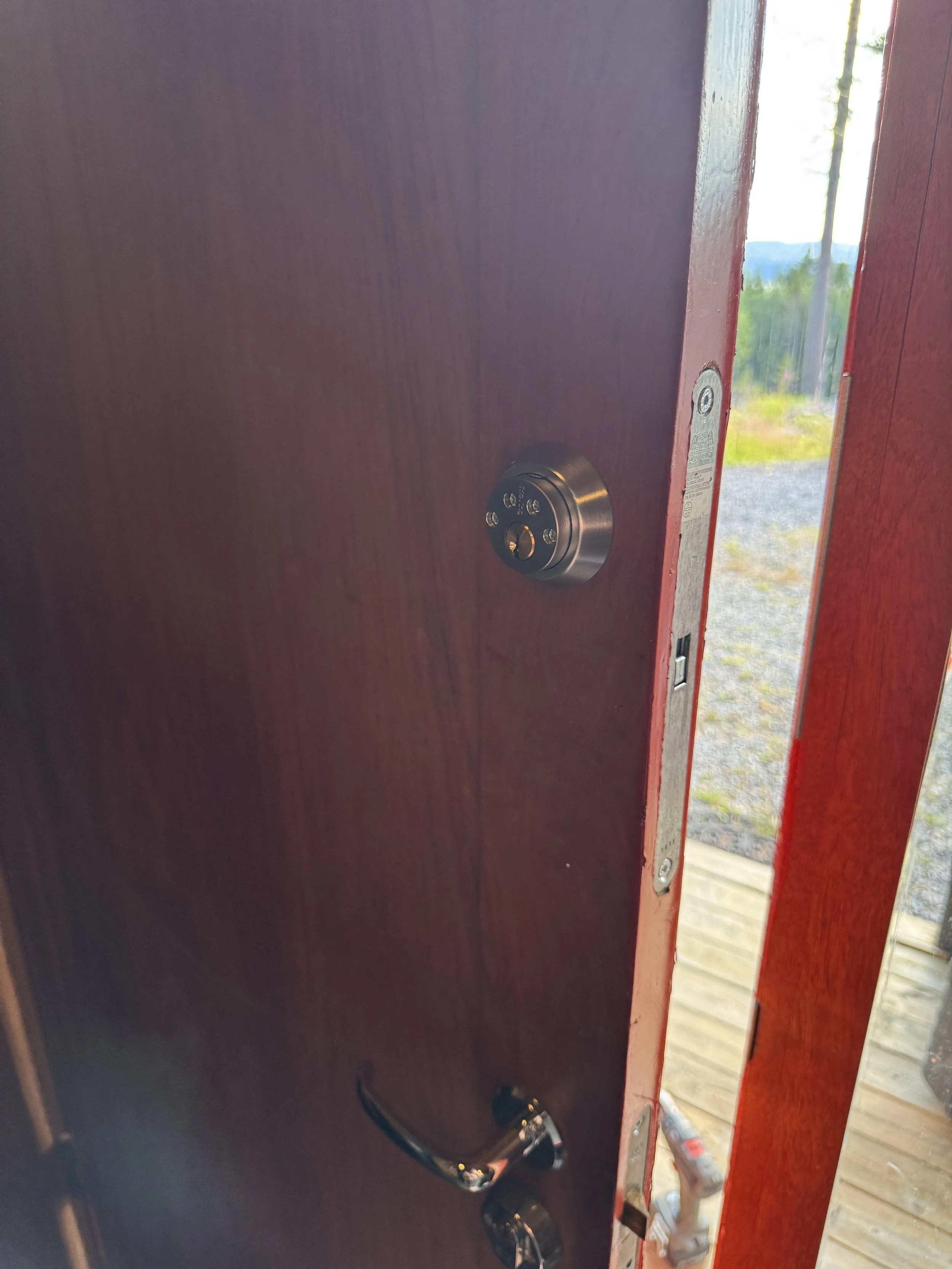 Innenfor en utadørs dør, nær bildet er en digital dørtelefonskjerm.