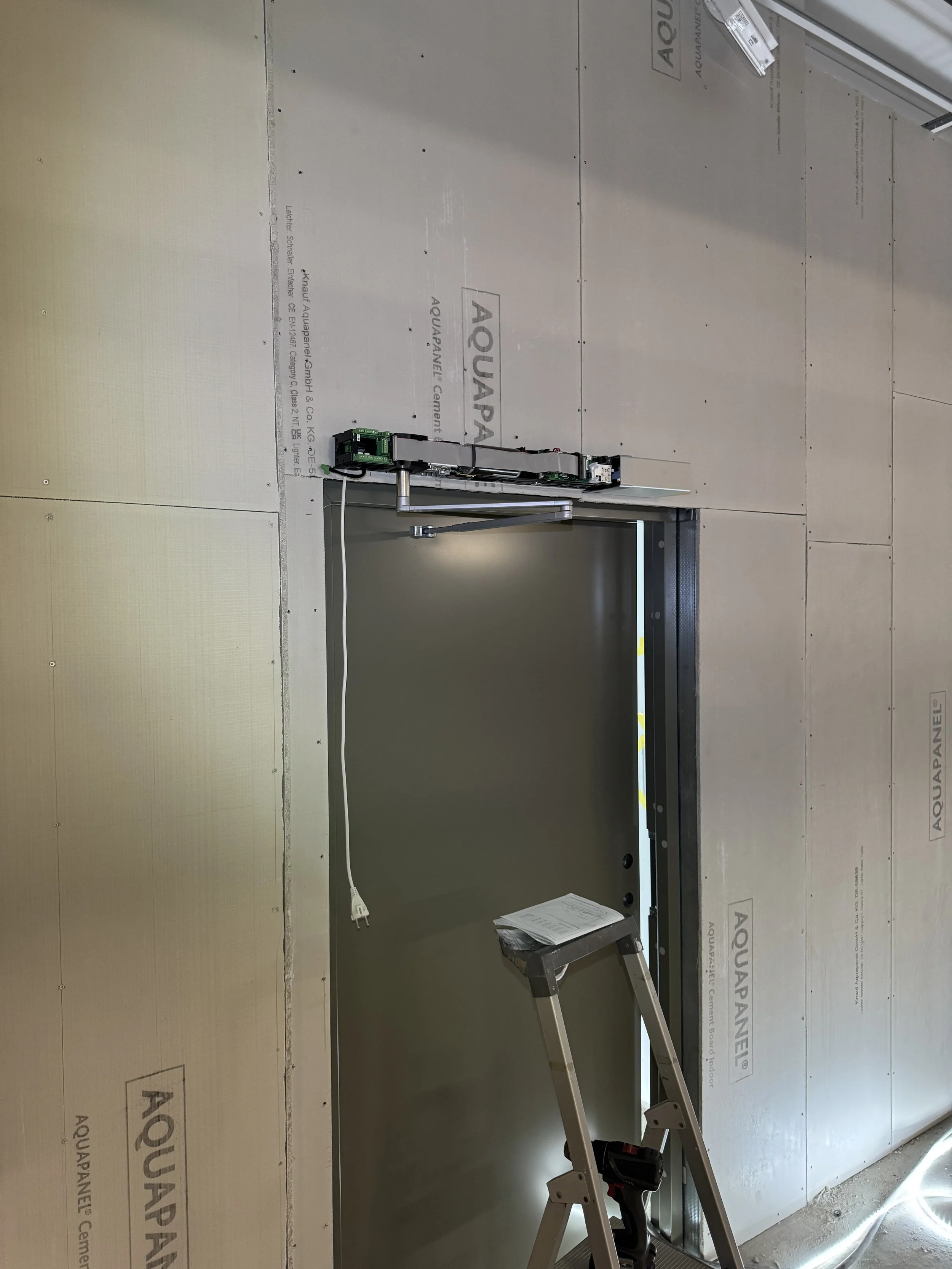 Bygging av bad eller kjøkken med innfelling til servanter eller lignende, omgitt av gipsplater, med en stige og elektriske komponenter foran åpningen.