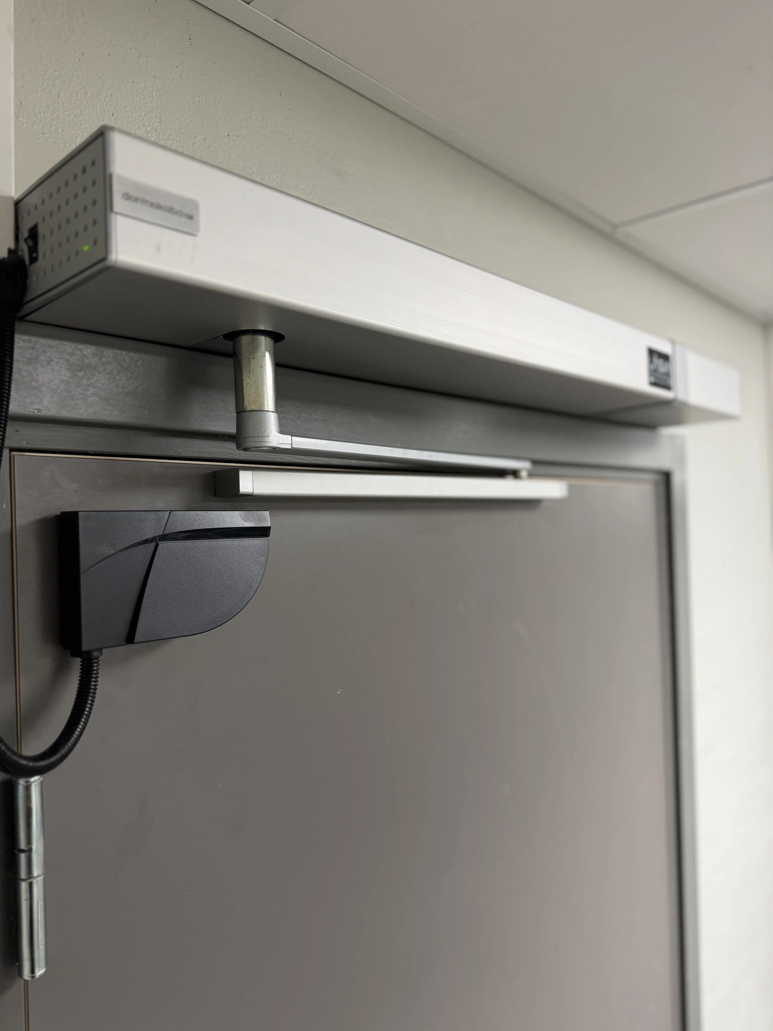 Nærbilde av en dør med en sikkerhetslåsemekanisme og en elektronisk lås.