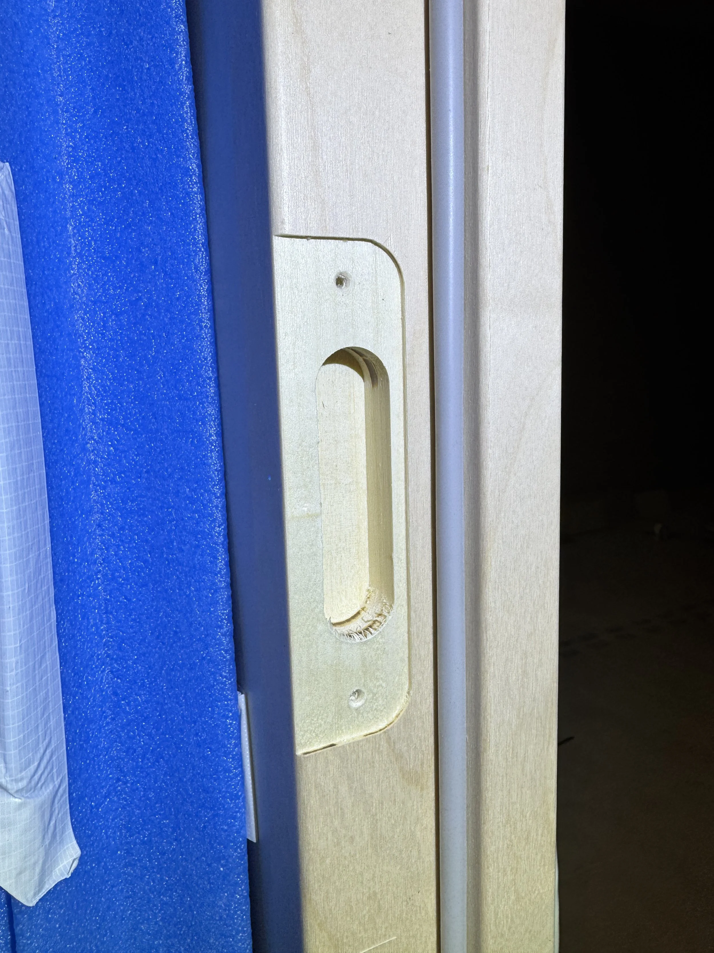 Nærbilde av en dørhåndtaksgrop uten håndtak, på en dør eller skuff.