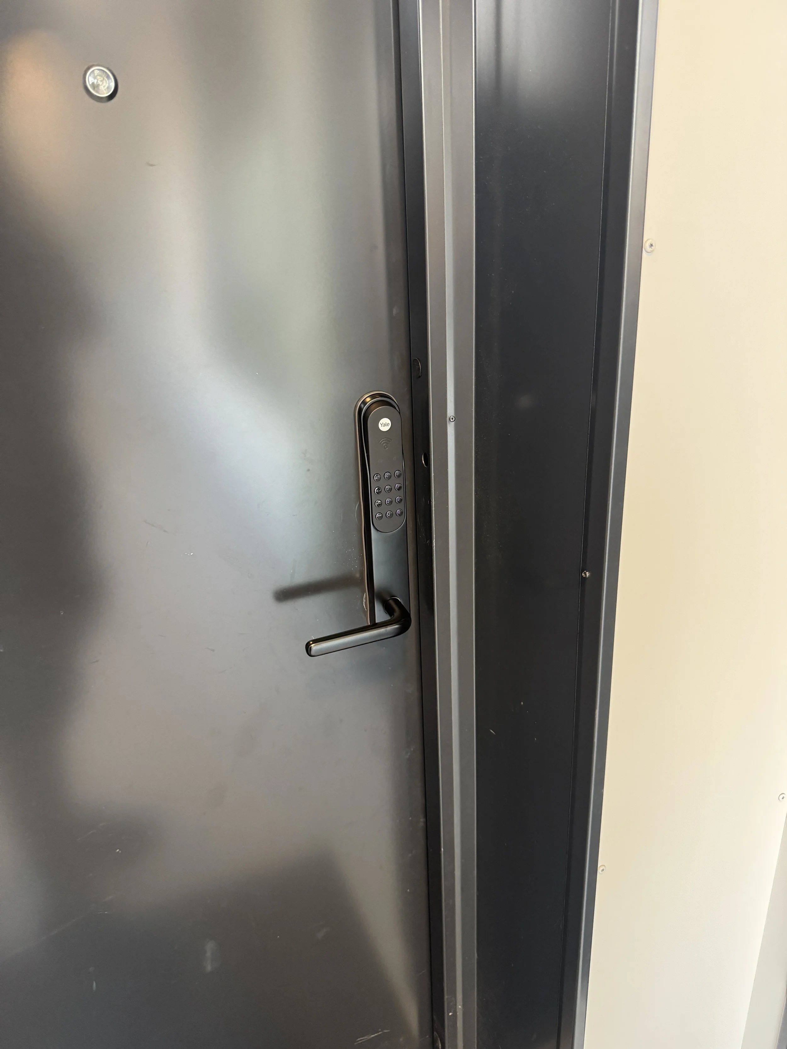 En metalldør med en elektronisk lås og kortleser.