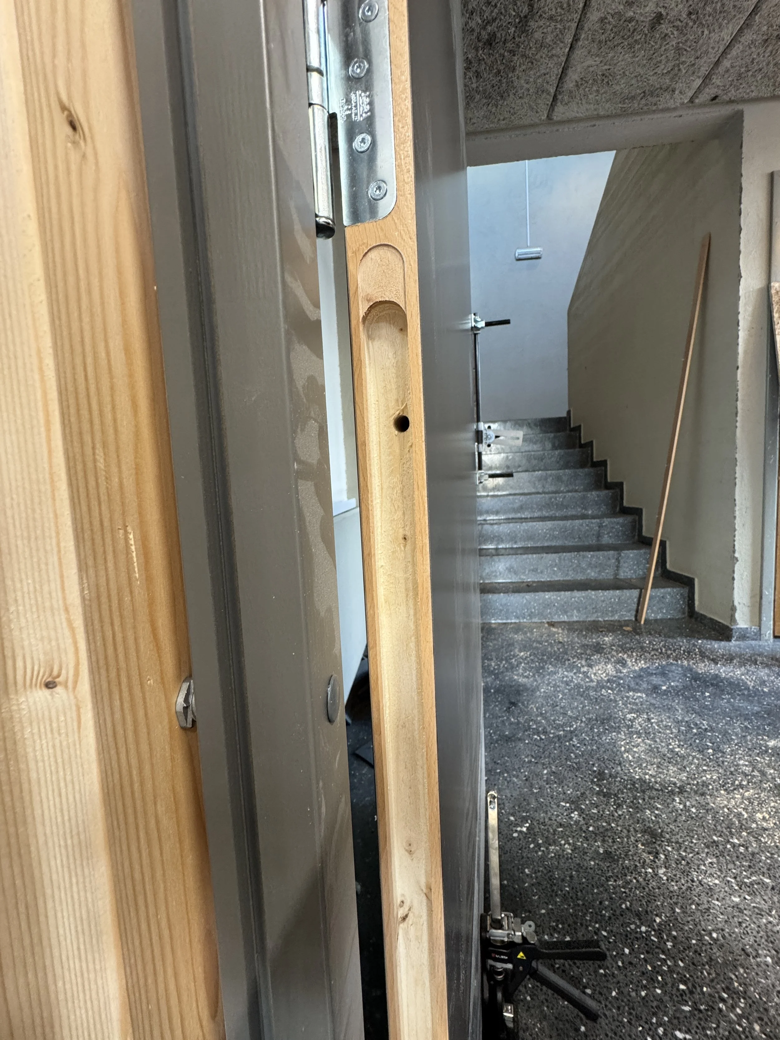 Beholder stilling med en trelist og et metallbeslag, muligens i forbindelse med bygging eller montering.