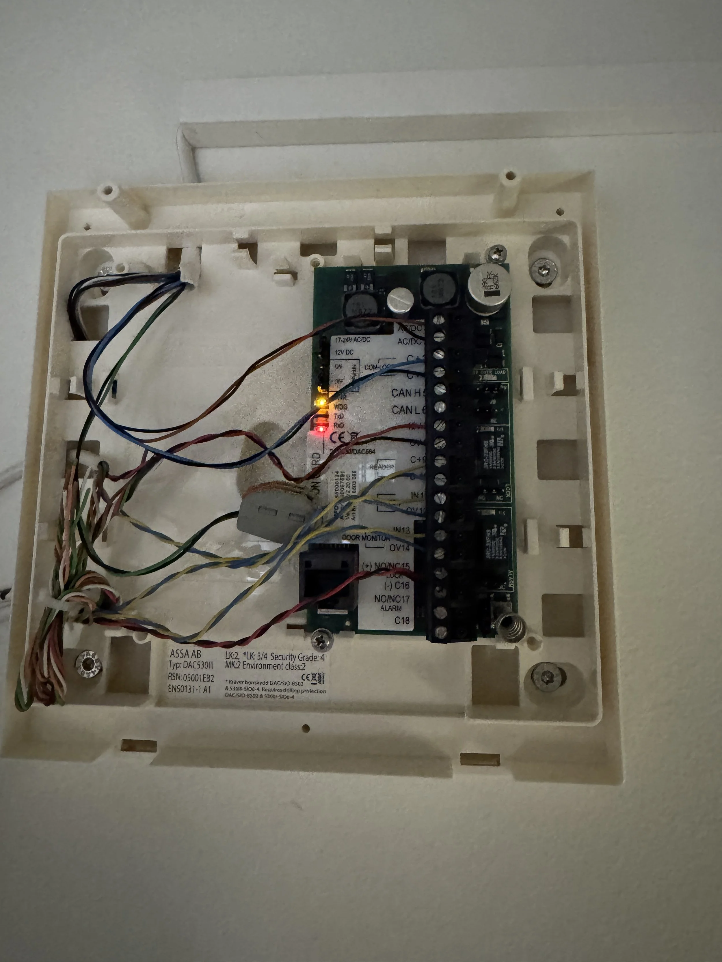 Elektrisk alarmsystemets kontrollpanel med ledelys og tilkoblede ledninger