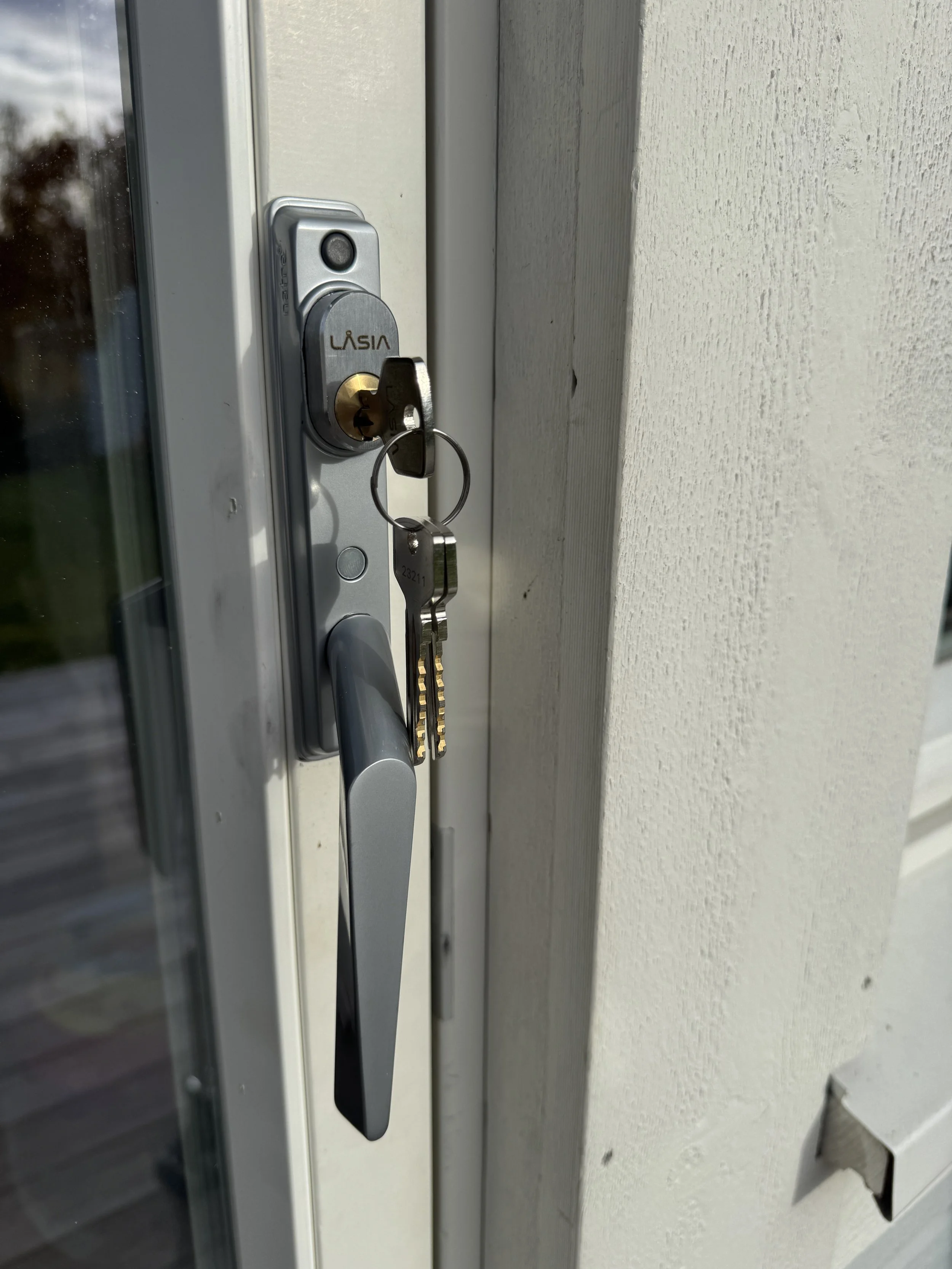 Dørhåndtak med nøkkel i lås på ytterdøren.