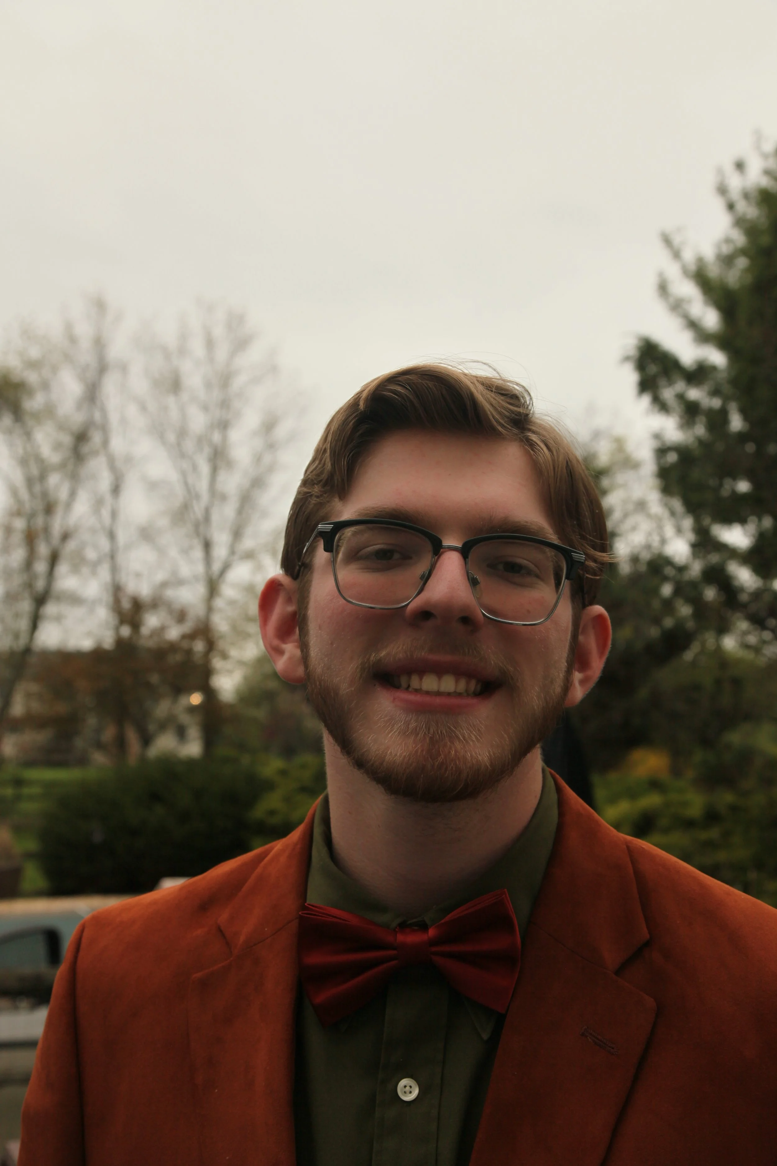 A headshot of a man outside in formal attire