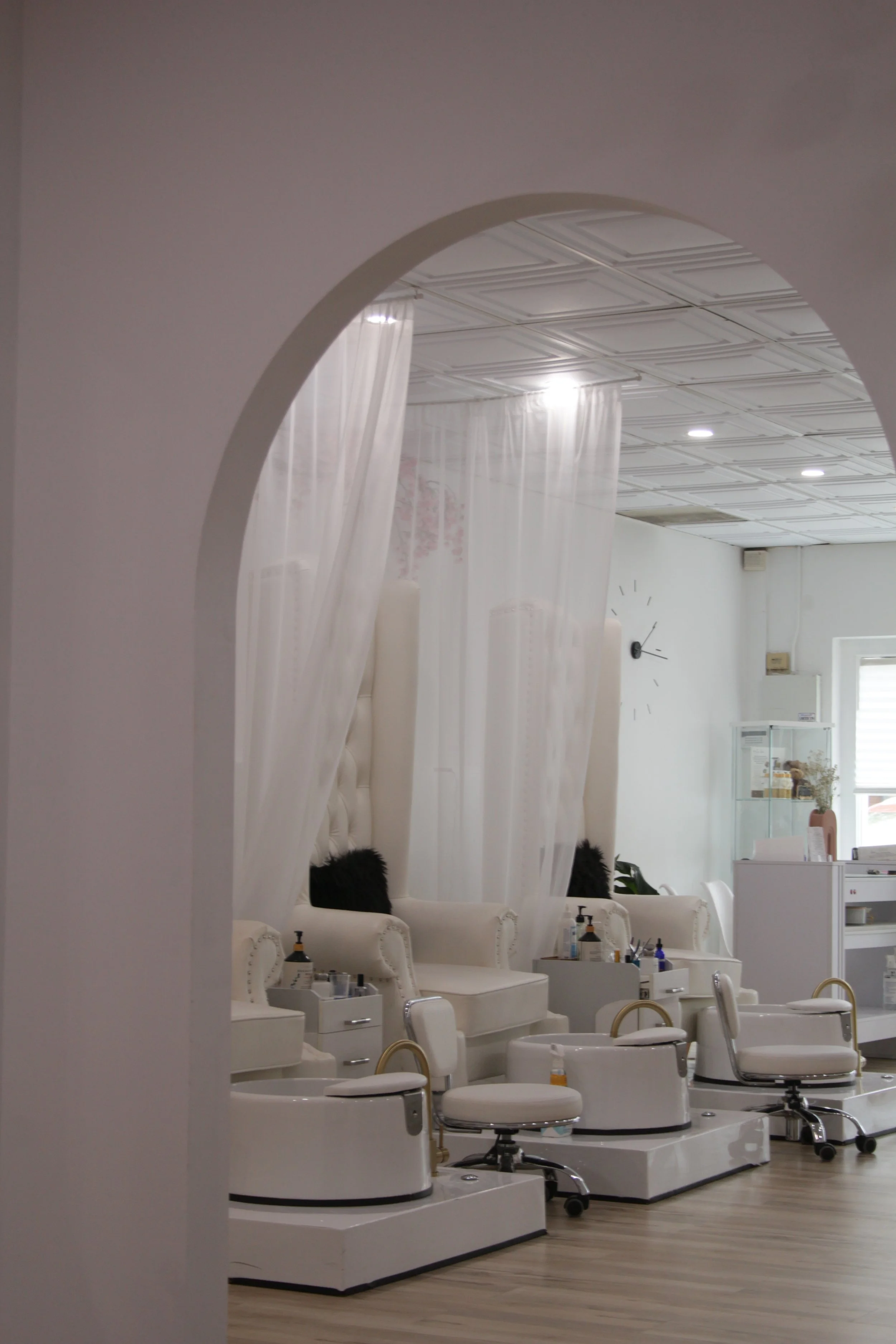 A photo of a nail salon through an arch doorway