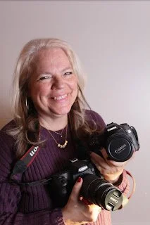 A headshot of a woman with her cameras