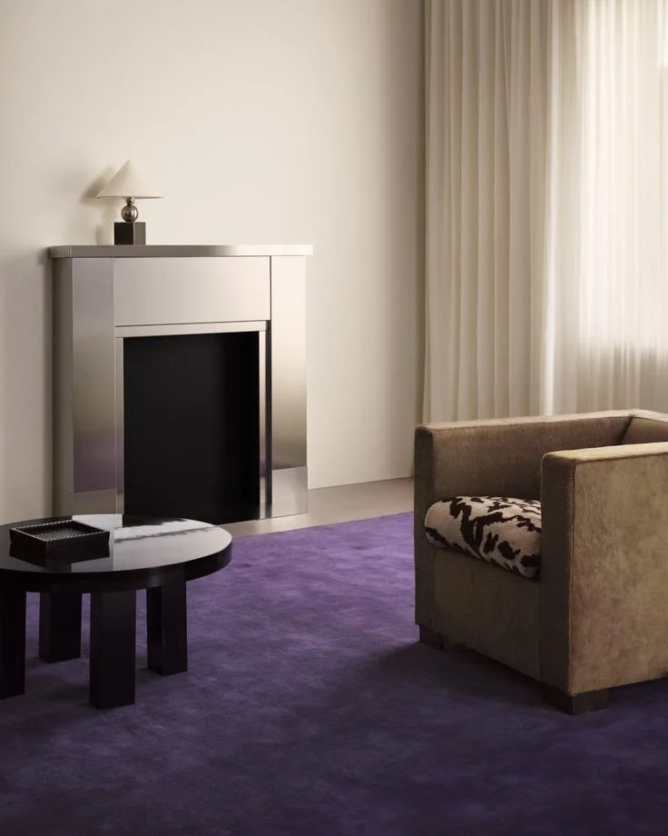 tapis marque nordic knots, cheminiée en acier métallique, table basse ronde noire, rideaux aux murs