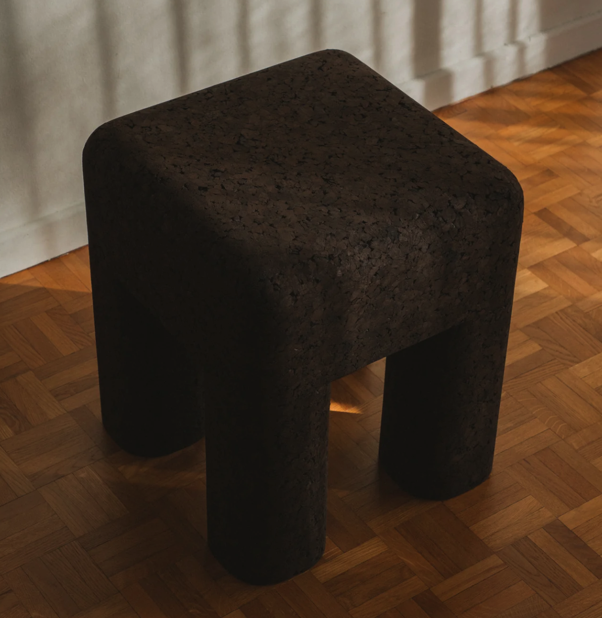 tabouret en liège noir par Mattina Moderna, sur un parquet miel 
