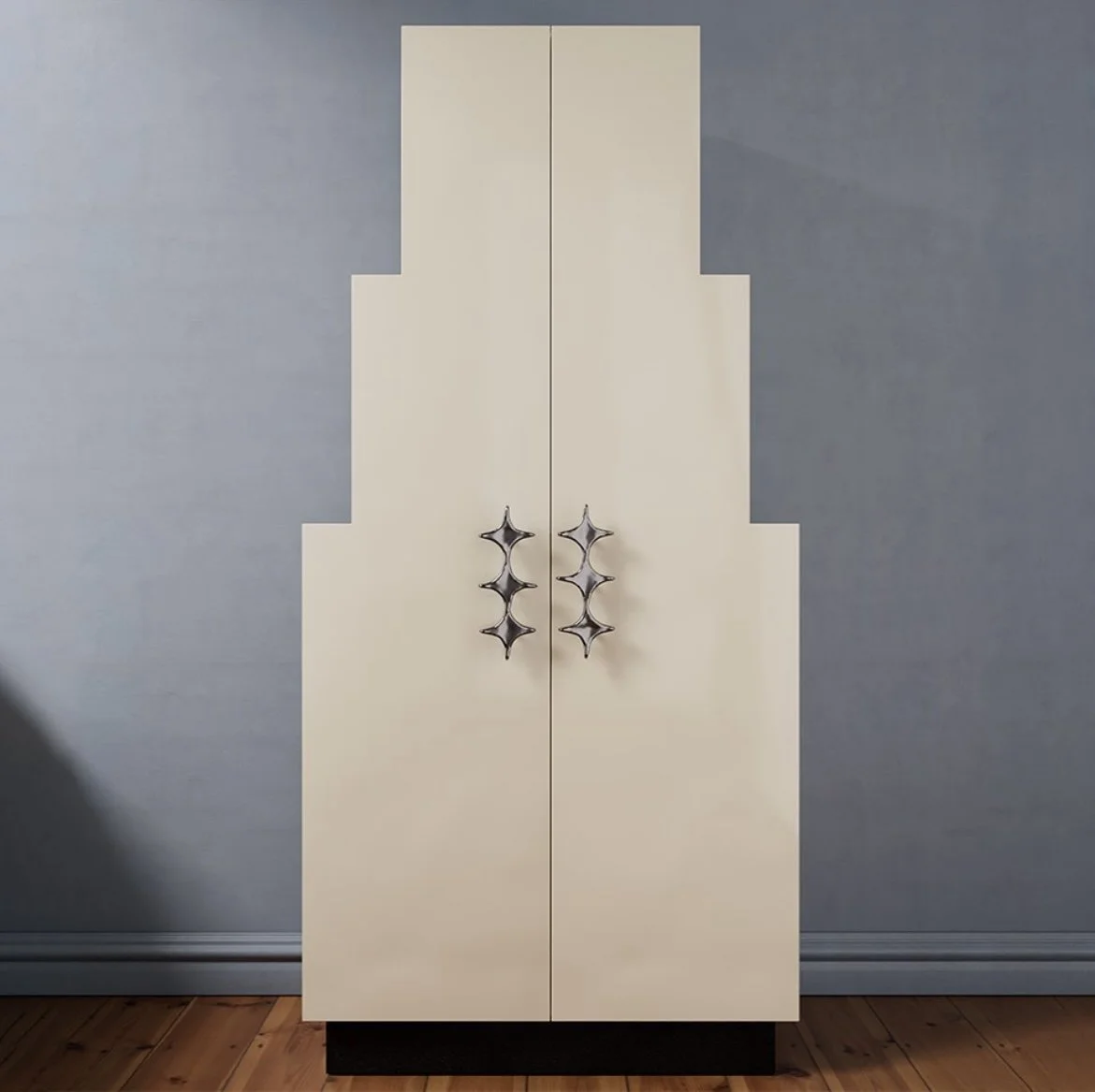 Armoire géométrique à plusieurs niveaux avec poignées métalliques argentées dans une pièce aux murs bleus