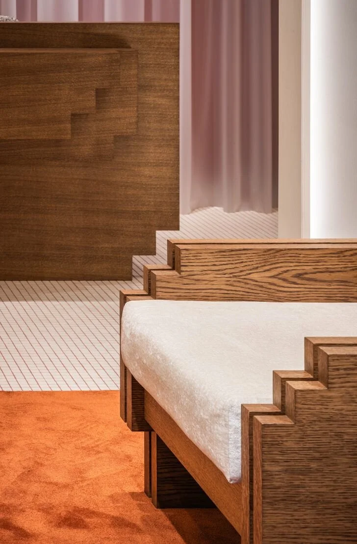 boutique avec mobilier géométrique en bois, tapis orange au sol sur carrelage graphique