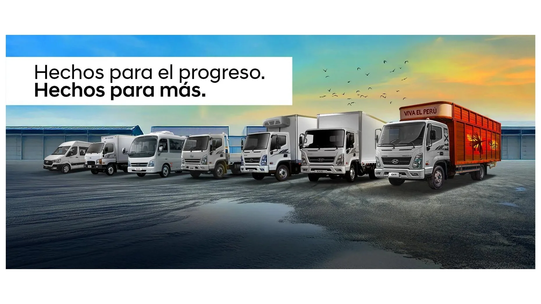 Variedad de camiones y buses Hyundai de diferentes tamaños y modelos en un estacionamiento al atardecer, con un mensaje que dice 'Hechos para el progreso. Hechos para más.'