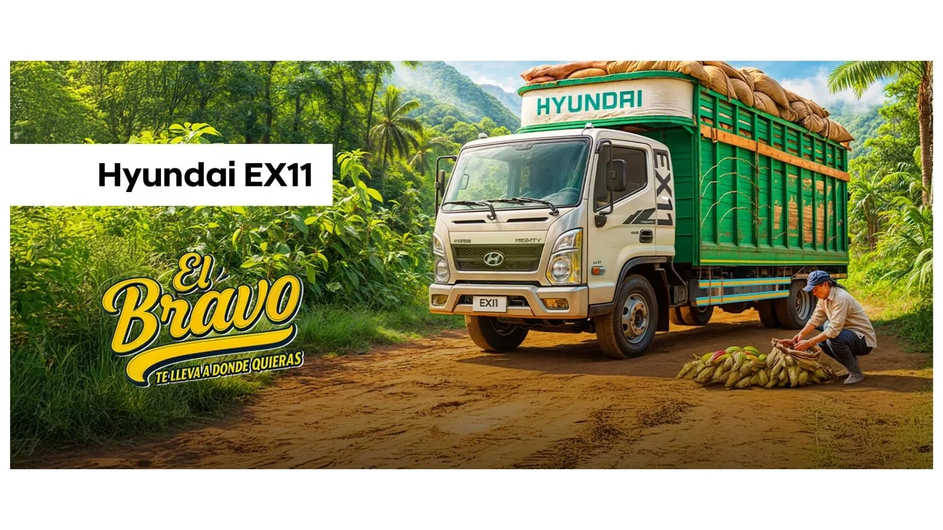 Camión Hyundai EX11 de color gris con caja de carga verde y saco de cacao en el suelo, en un camino rural rodeado de vegetación y árboles
