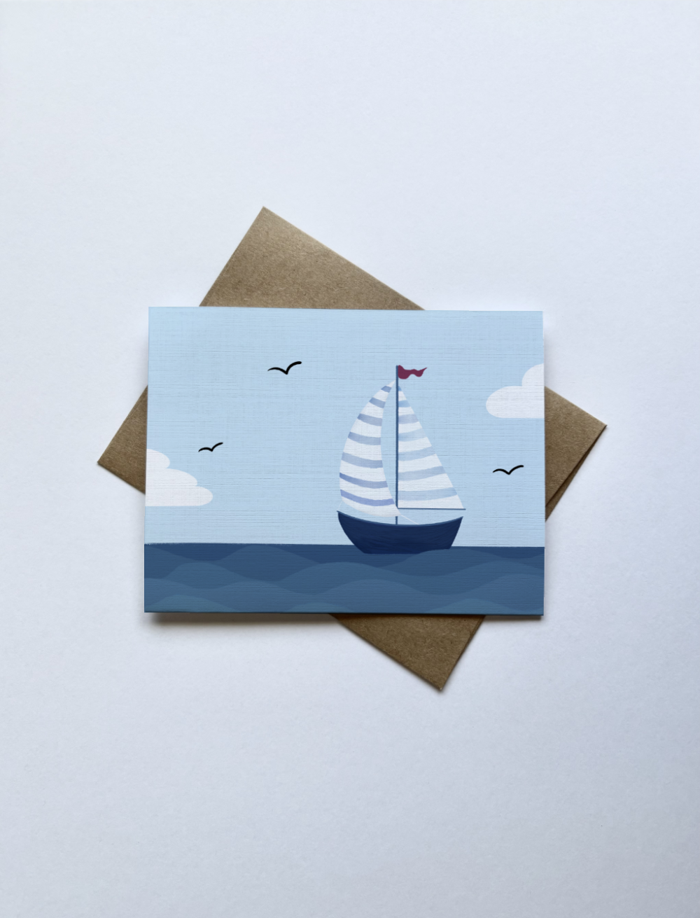 A blank inside card with a storybook-style sailboat greeting card featuring drifting clouds and open water—perfect for graduations, encouragement, and new beginnings.