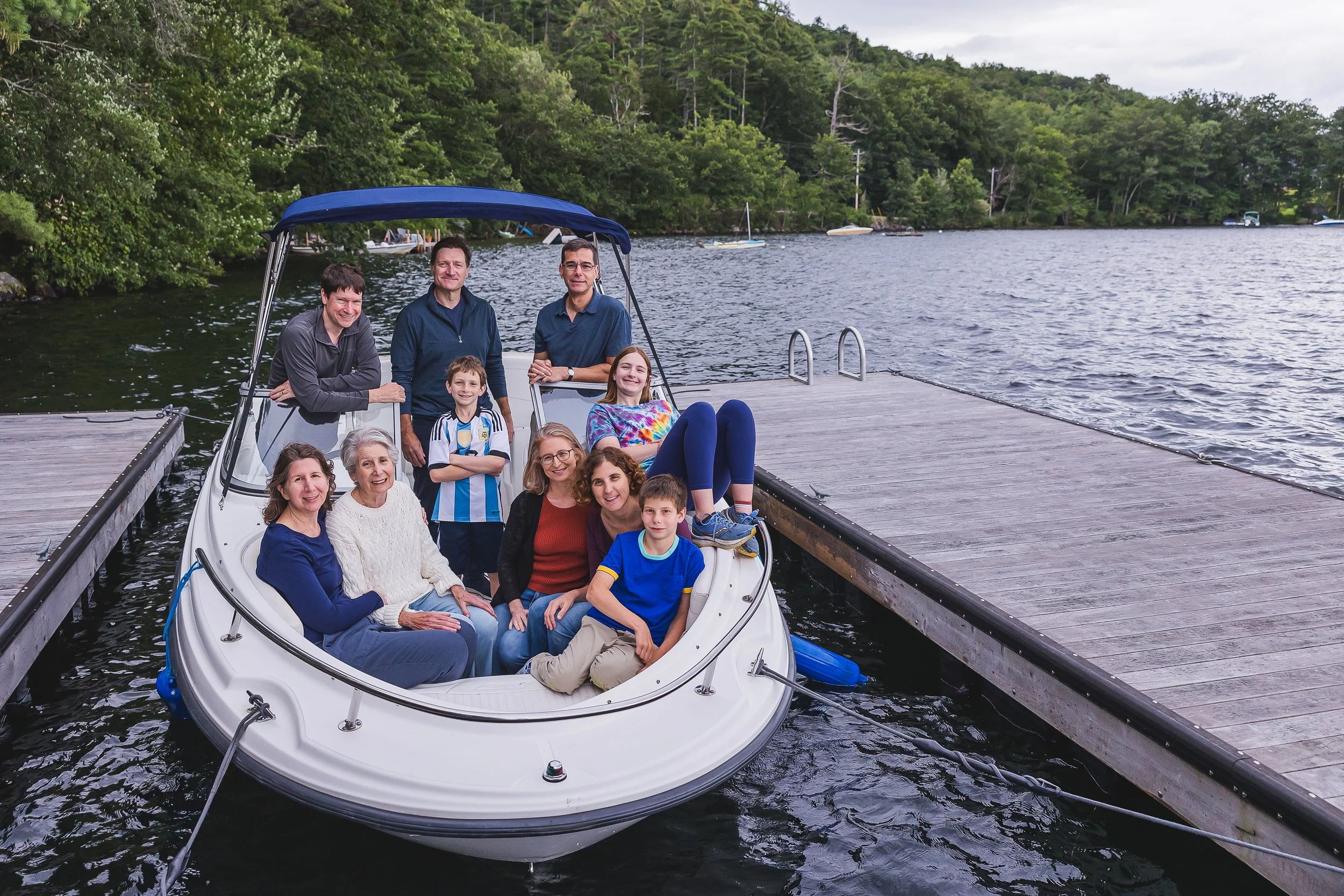 Family pose on a boat in the New Hampshire lakes region
