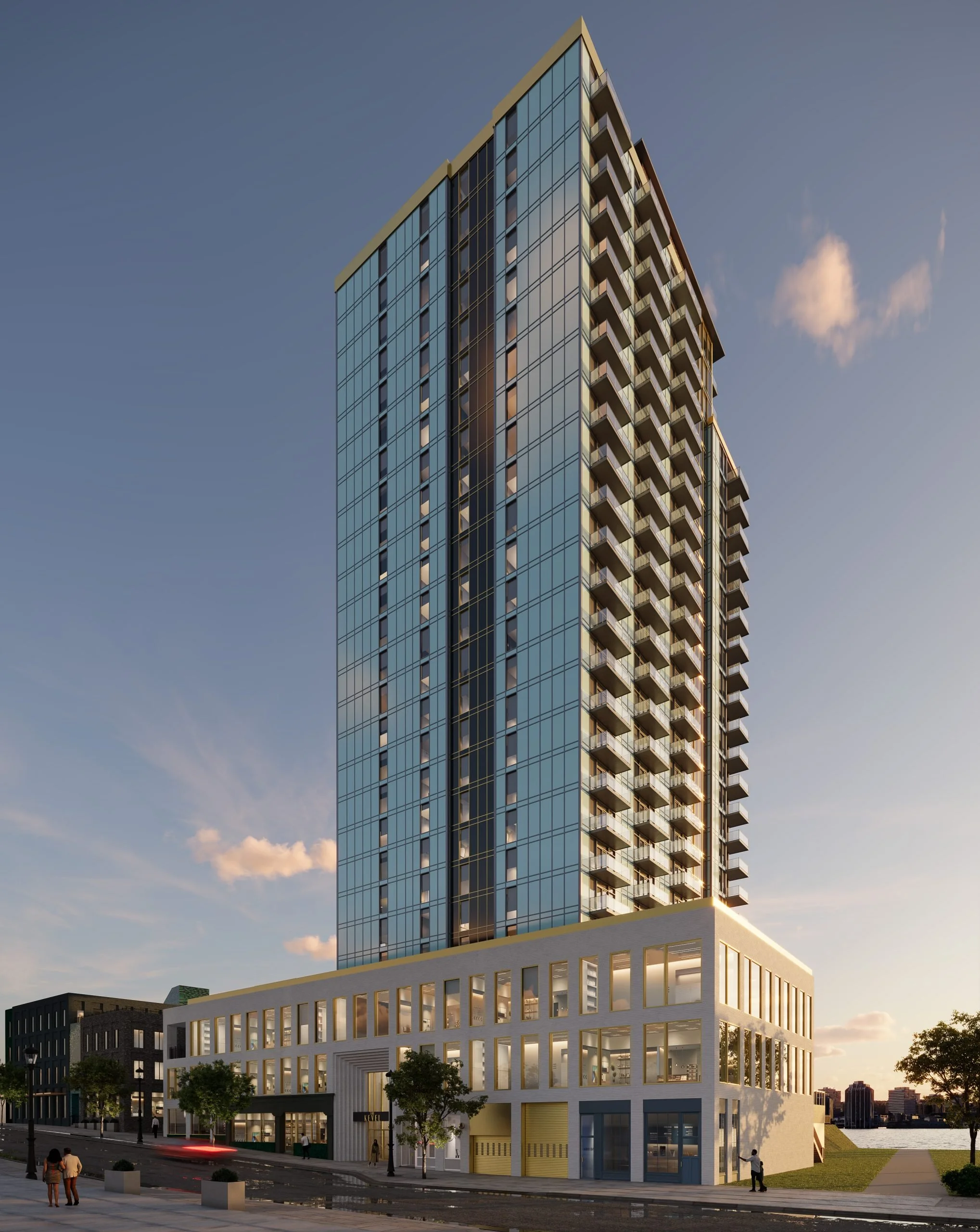 A tall modern high-rise building with glass windows and balconies, situated on a city street with pedestrians and trees, under a clear sky during sunset.