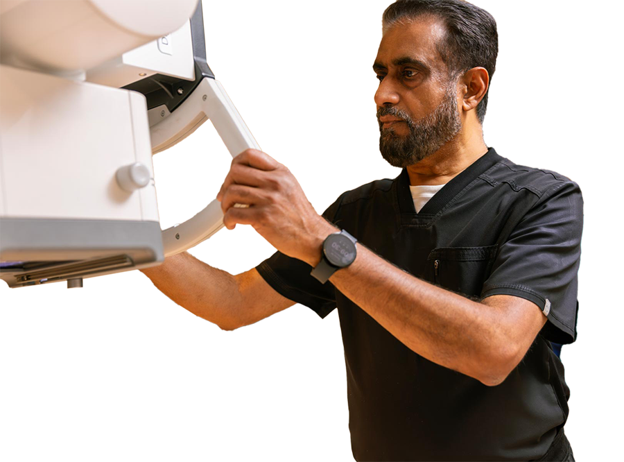 A male healthcare professional adjusting a medical imaging device.