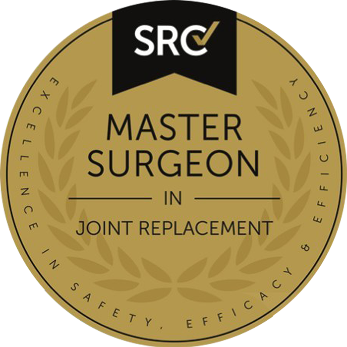 Gold circular badge with black top banner reading "SRC" and a check mark. In the center, it says "Master Surgeon in Joint Replacement" with surrounding text "Excellence, Safety, Efficacy & Efficiency."