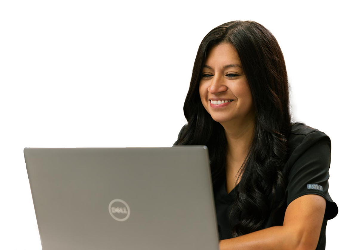 A woman with long dark hair smiling while using a Dell laptop.