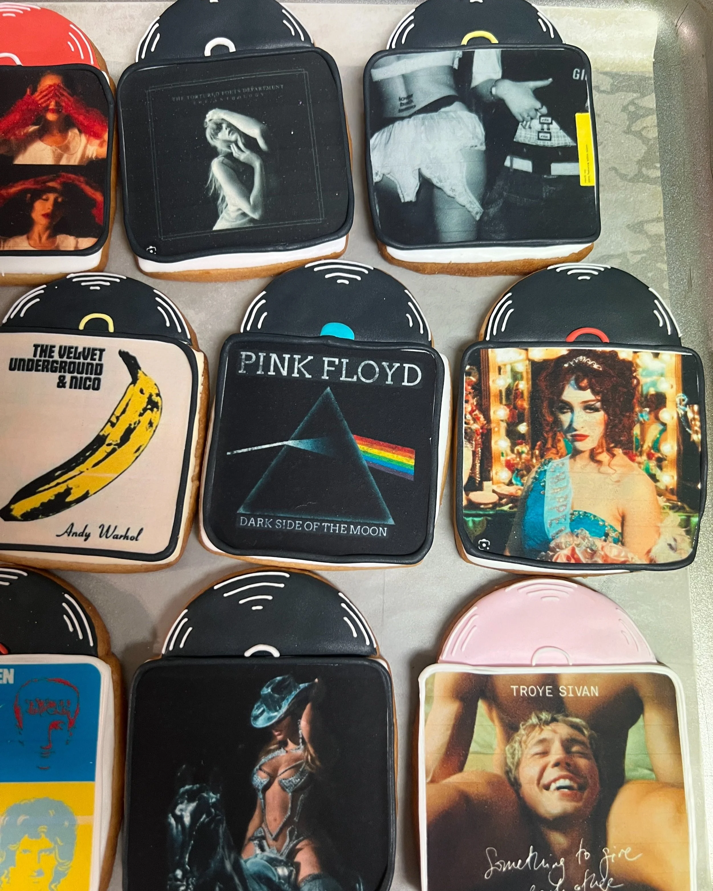 Decorated cookies with album covers of various artists and albums, including Pink Floyd's "Dark Side of the Moon," The Velvet Underground & Nico, and Troye Sivan.