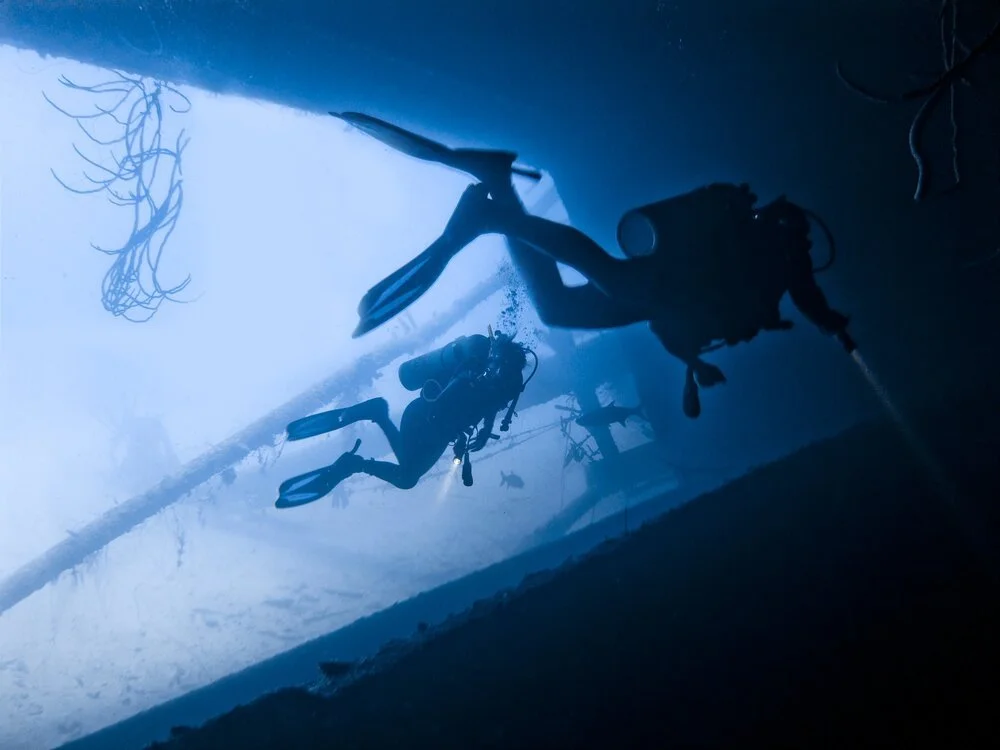 Scuba divers diving in a wreck.
