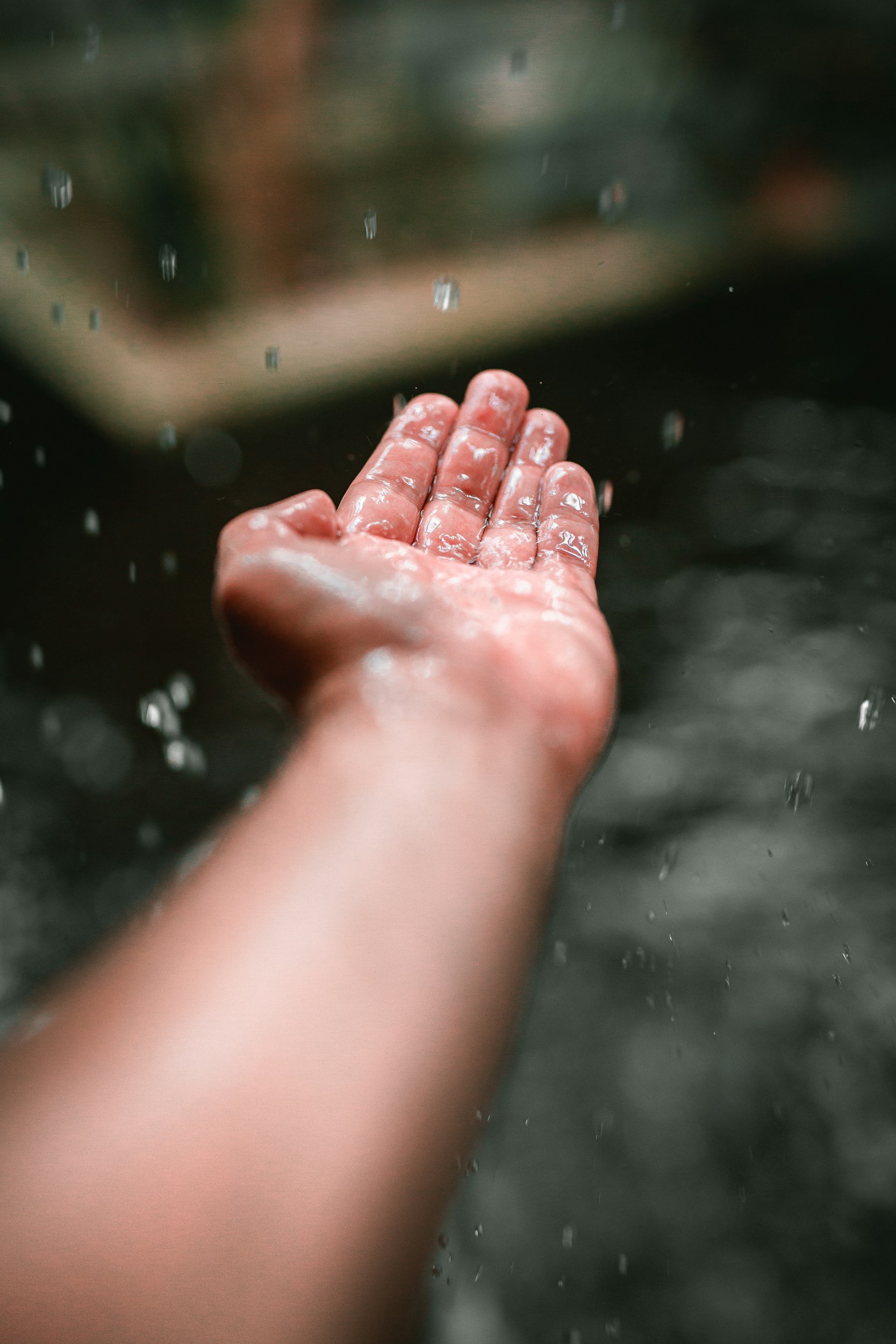 A person's hand to collect water droplets of rain.