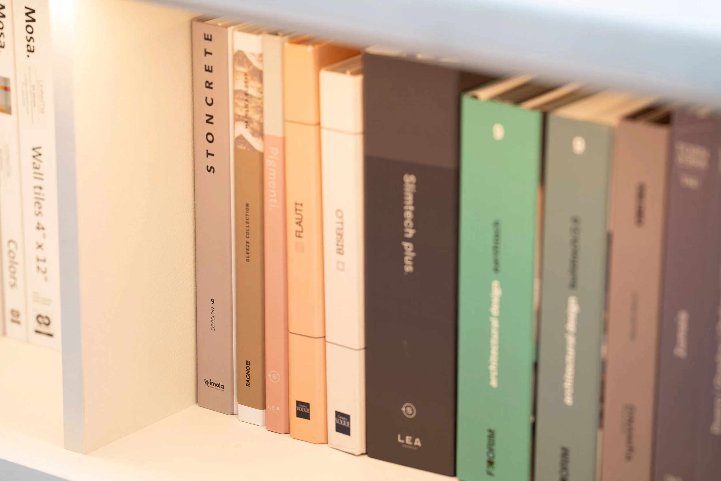Books on a shelf with titles including 'Stonecrete,' 'Pigmenti,' 'Flutti,' 'Disgello,' 'Shitface Plus,' and 'Kokom' on colorful covers.