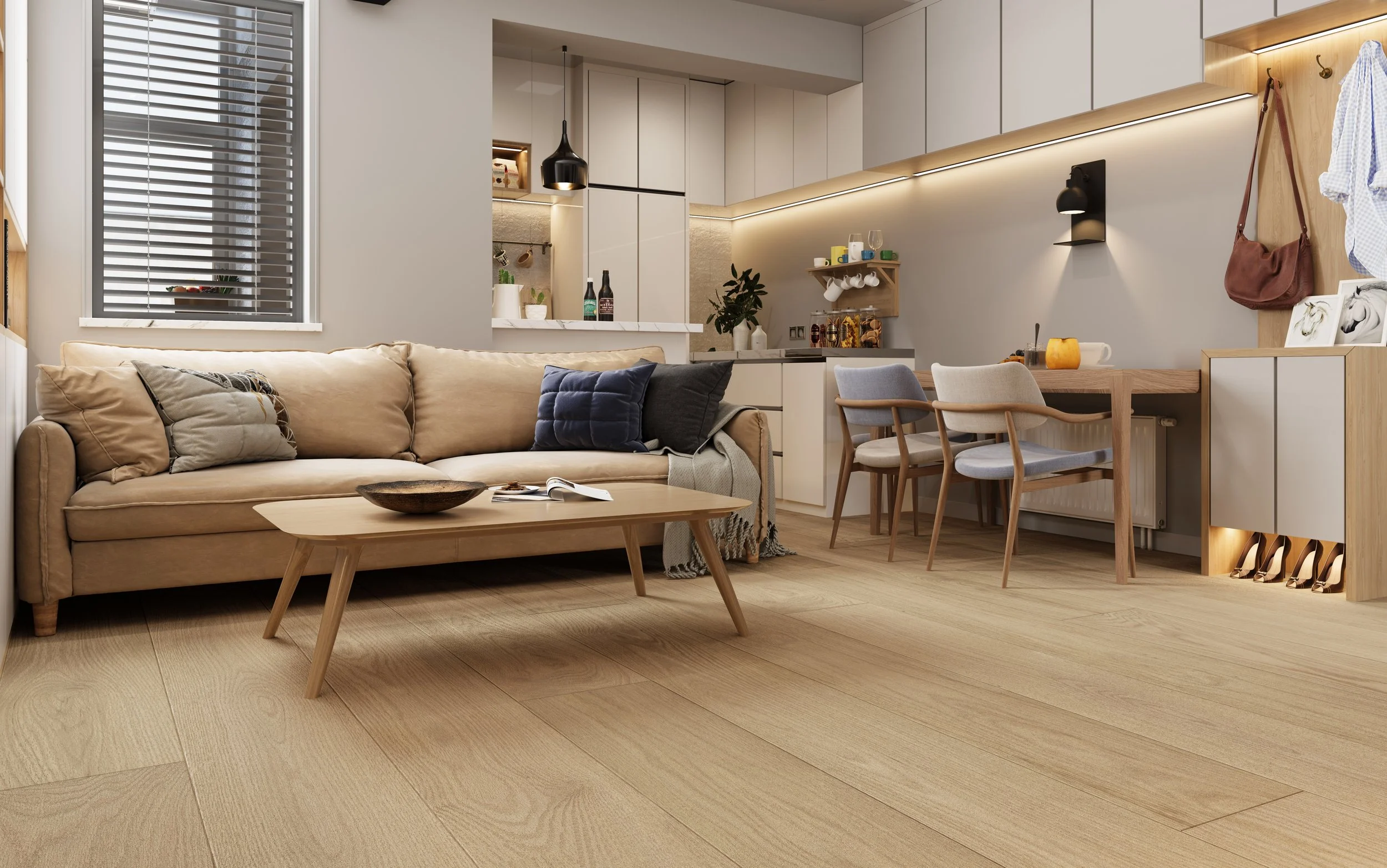 Modern open-plan living room with a beige sofa, wooden coffee table, and a dining area with three chairs, adjacent to a kitchen with white cabinets and a small wall-mounted shelf. The room has wooden flooring, a window with gray blinds, and warm lighting.