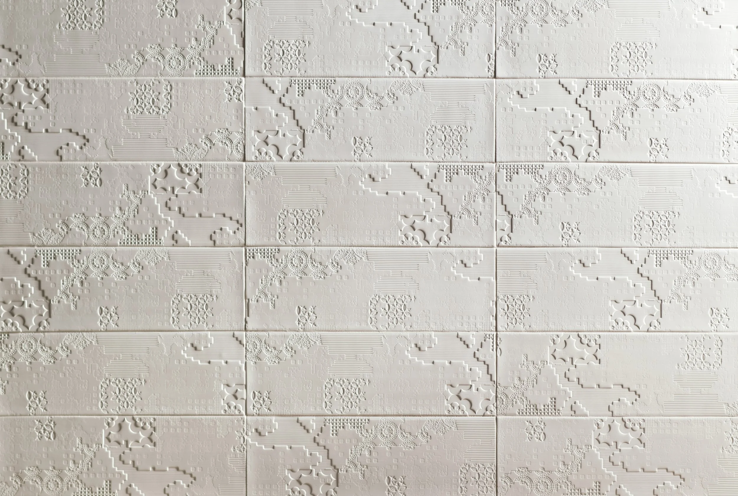 White textured tiles with embossed patterns forming a detailed world map.