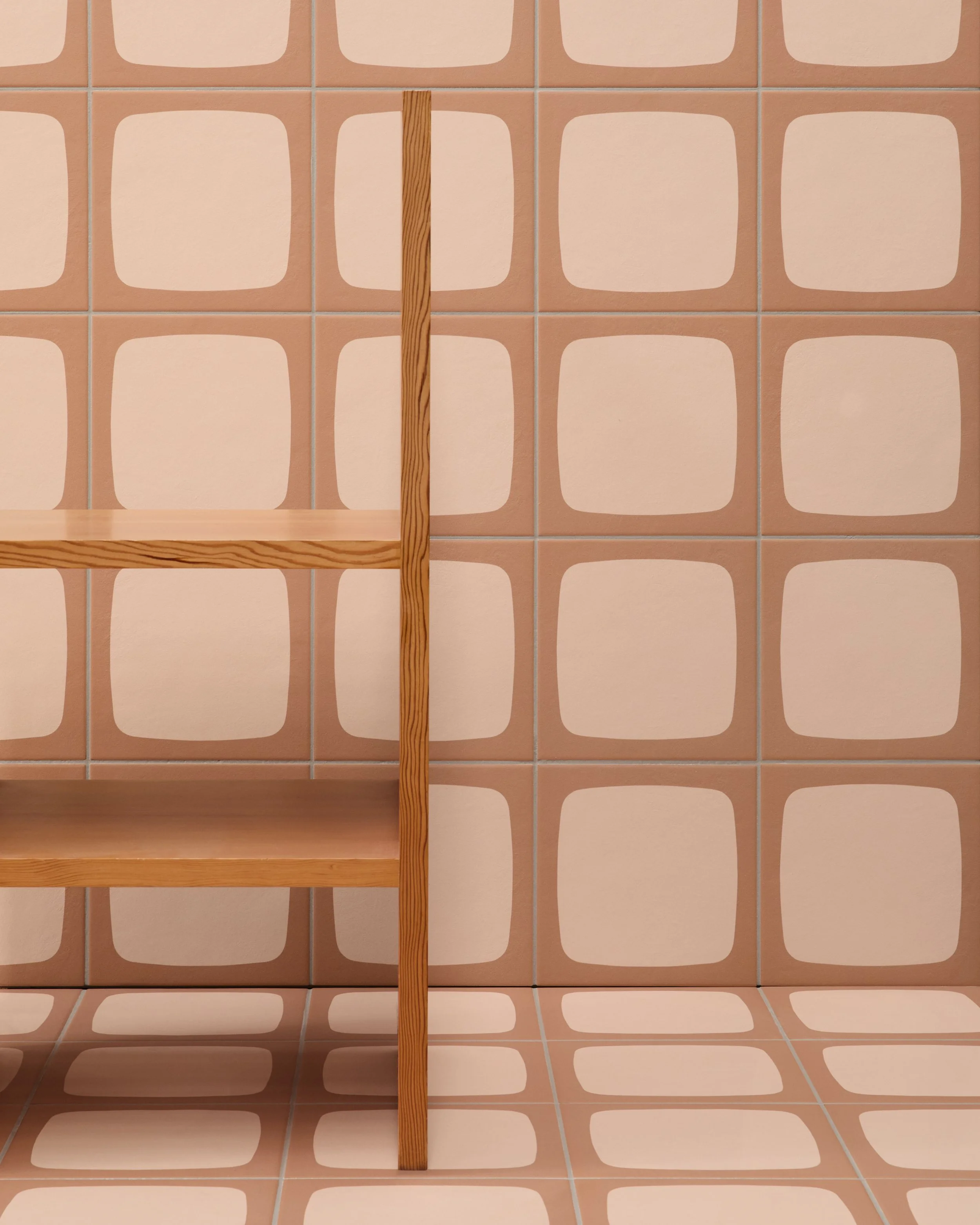 A corner of a room with retro brown and beige square tiles on the wall and floor. There is a wooden shelf with two shelves and a vertical support in the center.