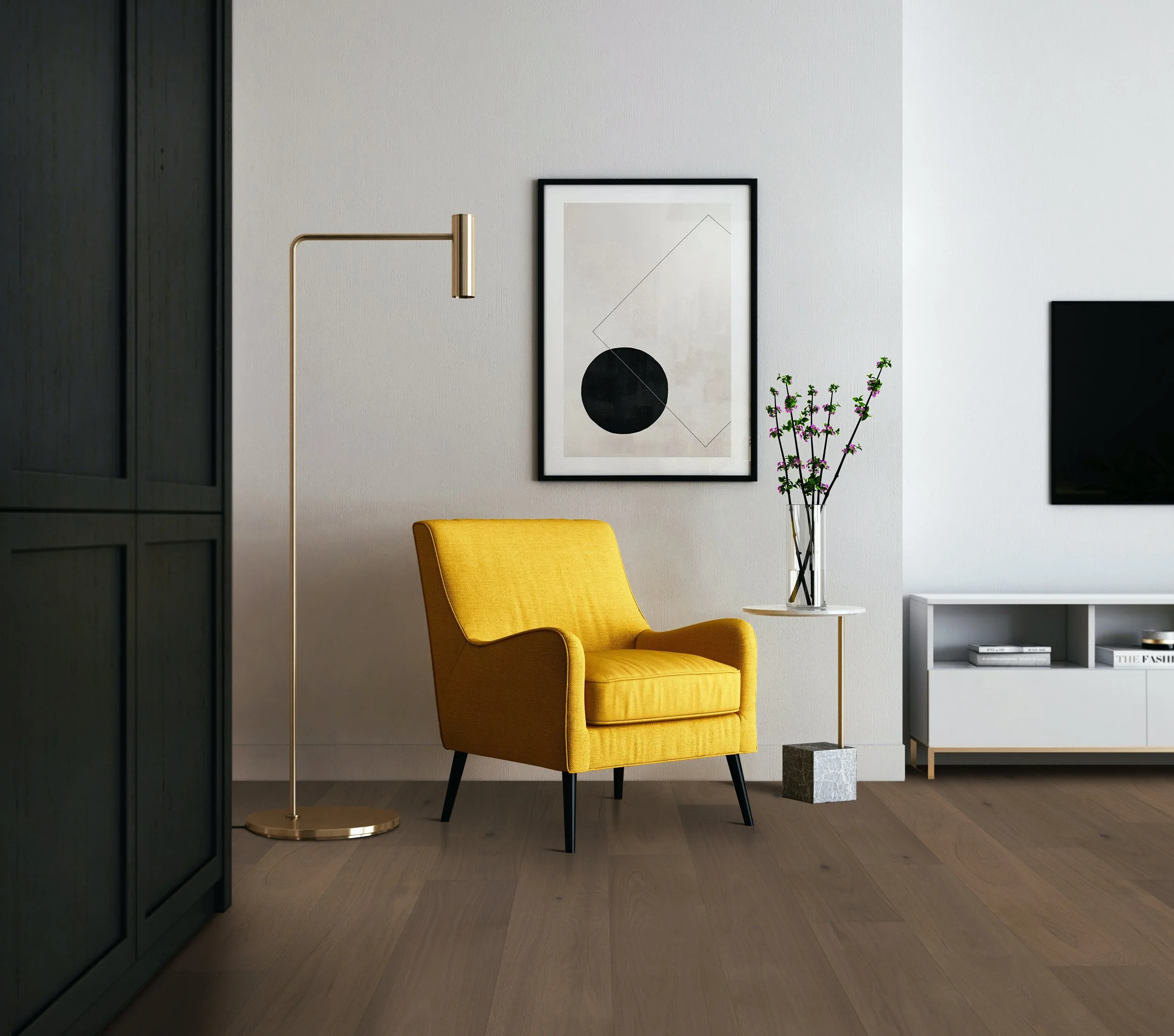 Modern living room with a yellow armchair, a tall gold floor lamp, a small side table with a vase of flowers, wall art, and a TV on a white console.
