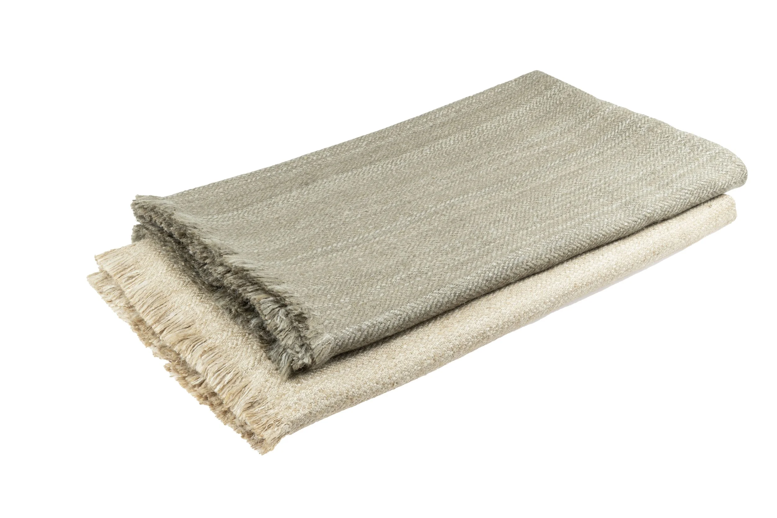 Three folded light-colored, textured blankets stacked on top of each other