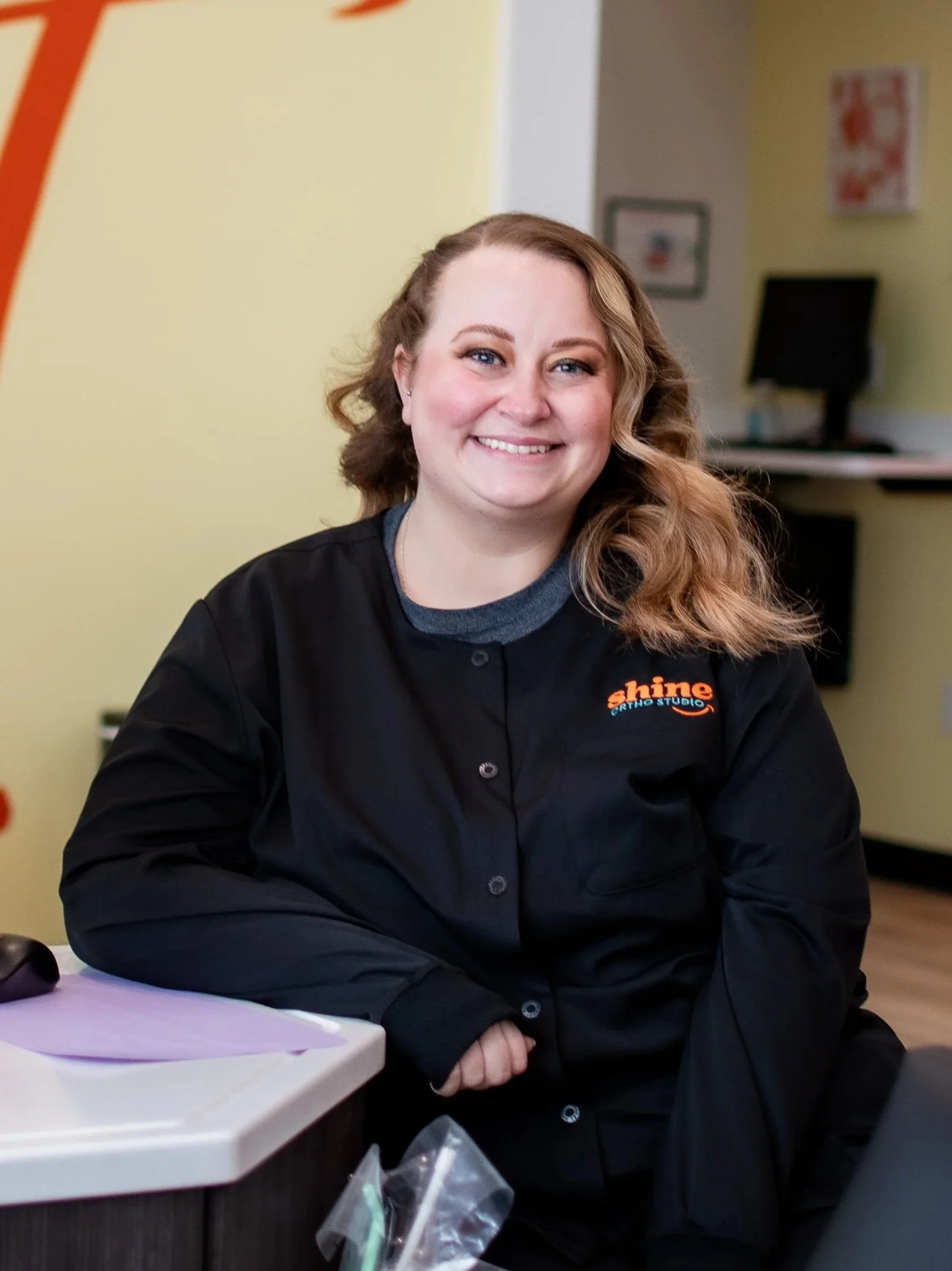 Taylor LaCourse, orthodontic dental assistant at Shine Ortho Studio, smiling in the treatment area