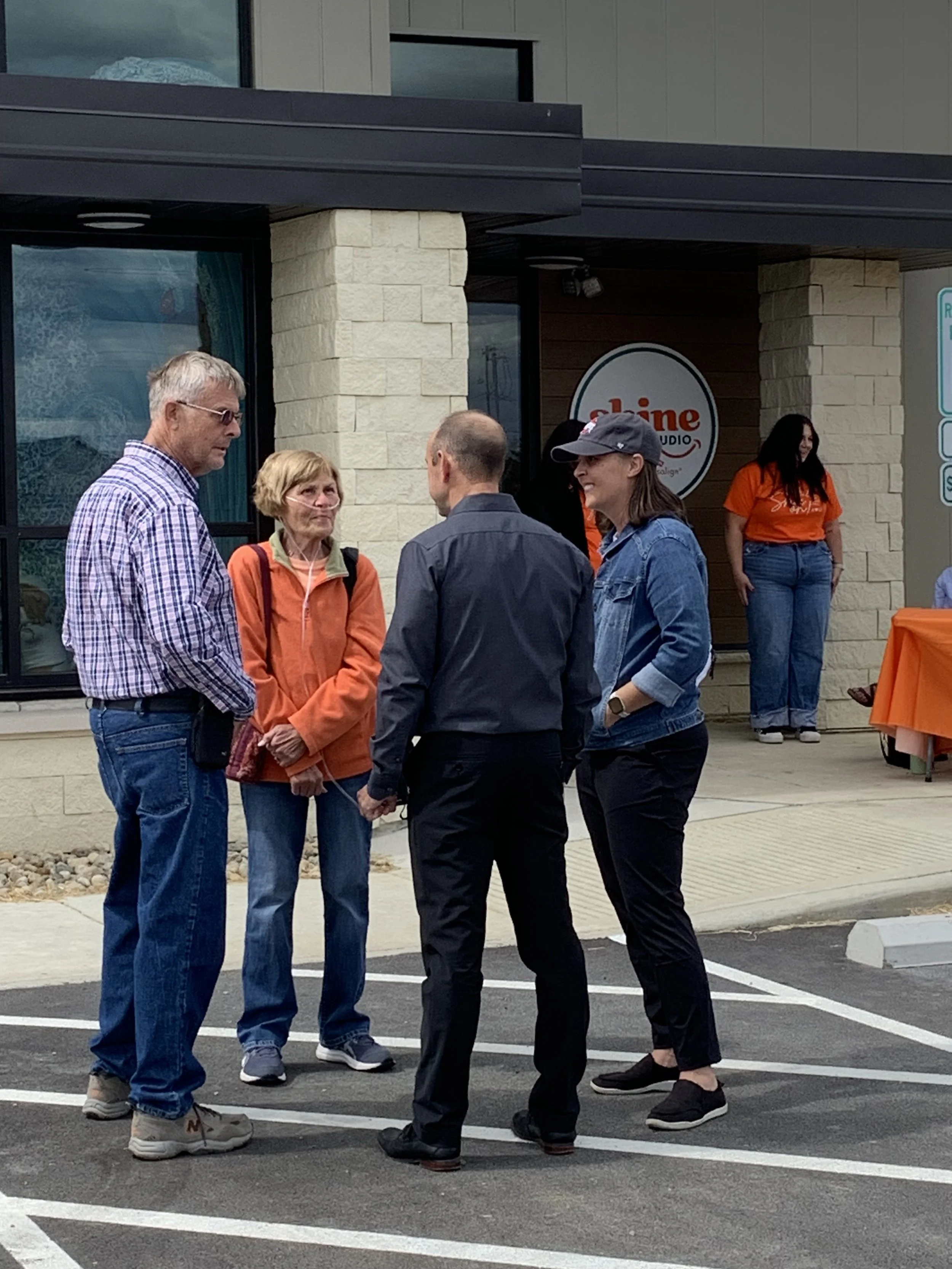 Community members and Shine Ortho Studio staff talking outside the office during the open house event.