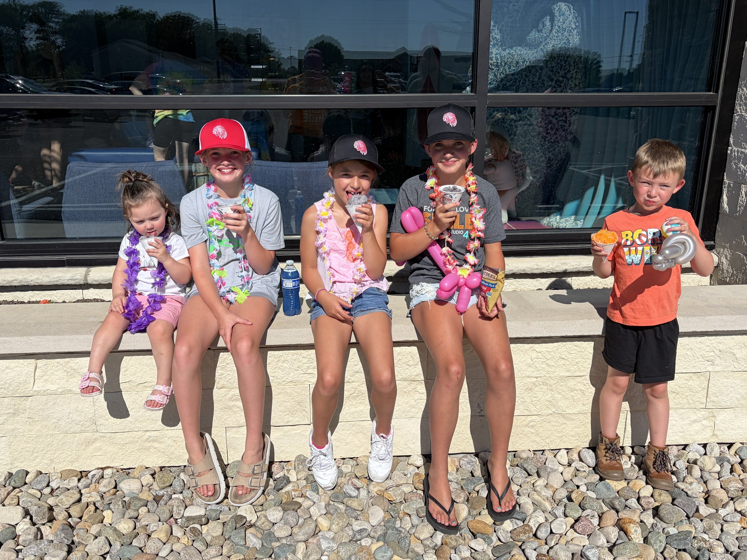 Children smiling with prizes and treats during Shine Ortho Studio's free Family Fun Day community event.